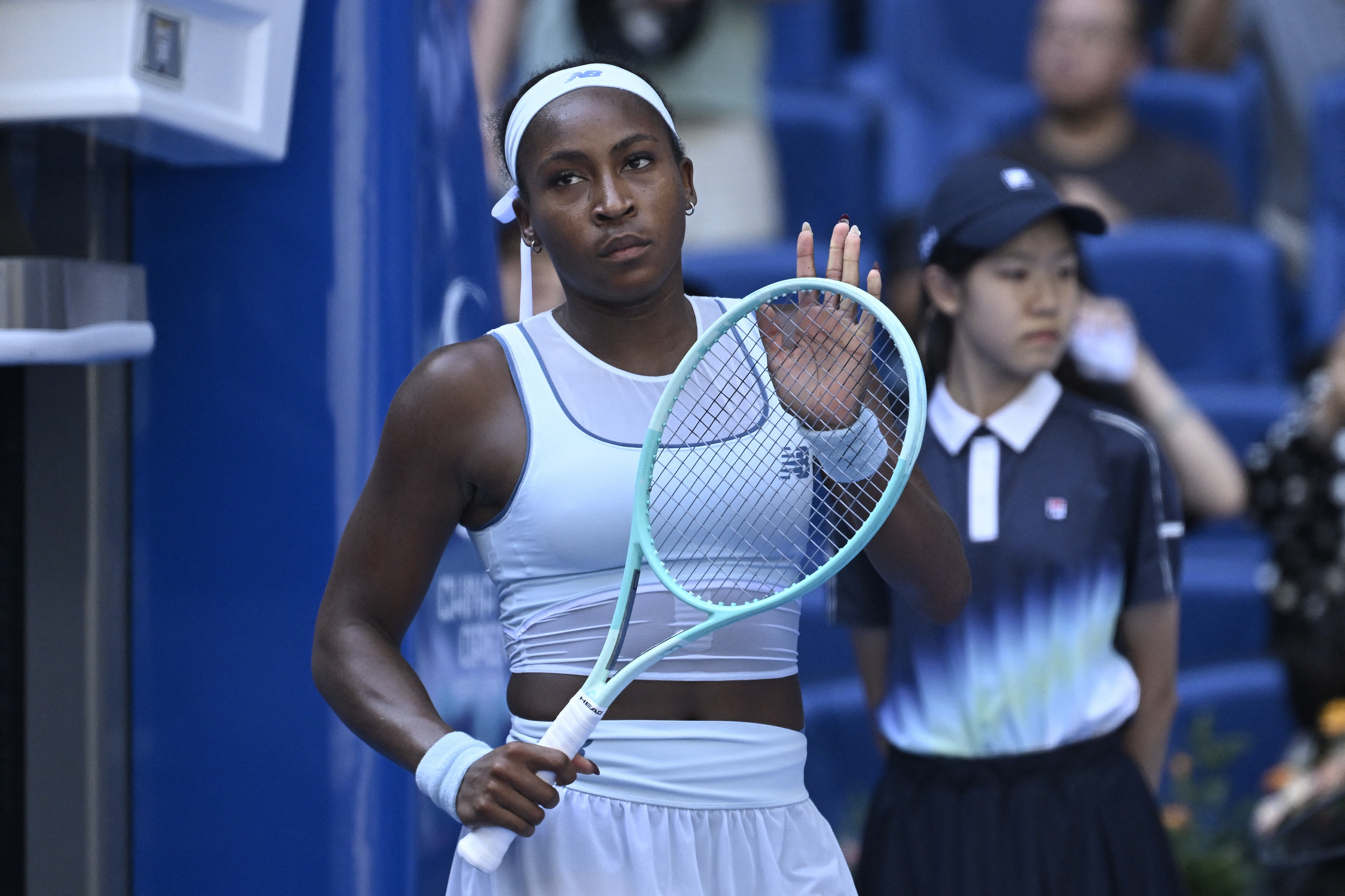 Coco Gauff reacts as she holds a tennis racquet.