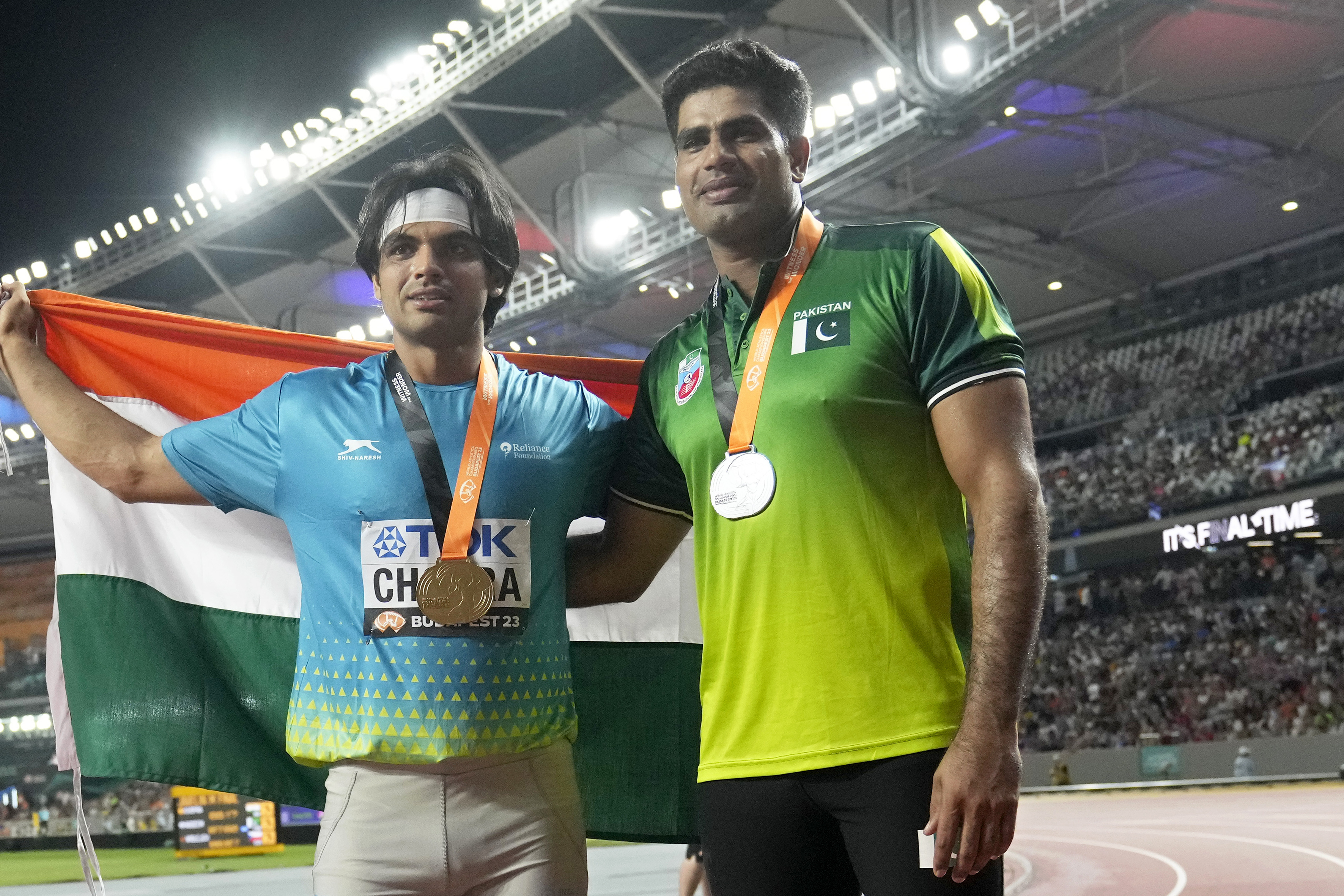 Gold medalist Neeraj Chopra, of India, and silver medalist Arshad Nadeem, of Pakistan, right, pose after finishing the Men's javelin throw final during the World Athletics Championships in Budapest, Hungary, Sunday, Aug. 27, 2023. (AP Photo/Matthias Schrader)