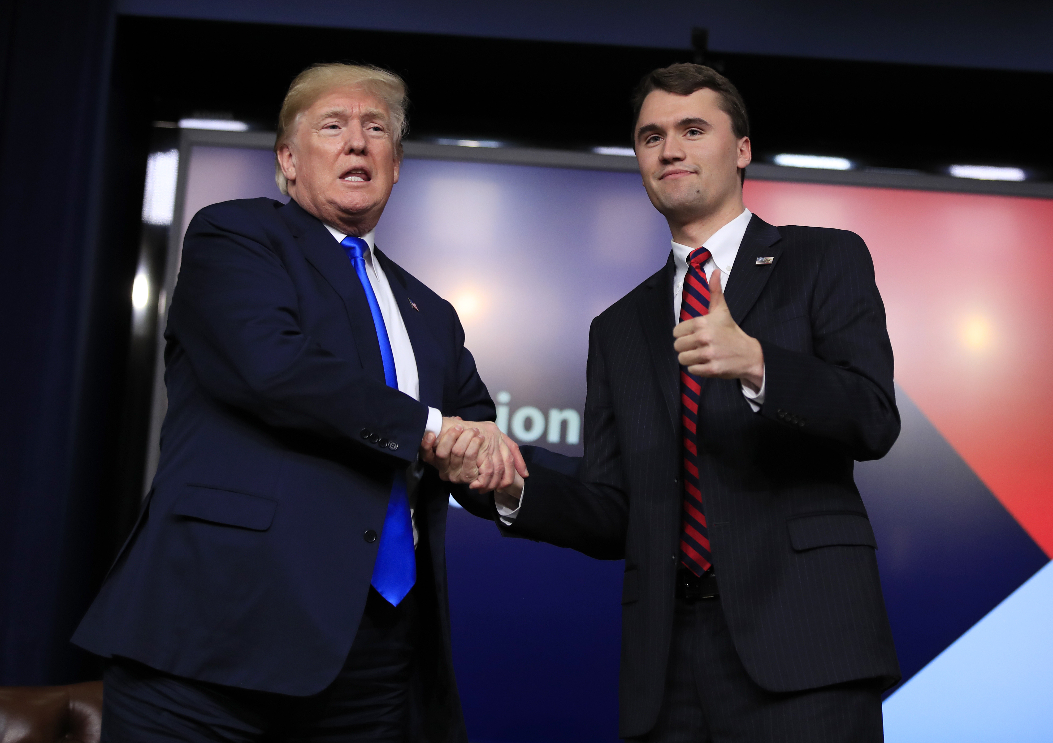 FILE - President Donald Trump shakes hands with moderator Charlie Kirk, during a Generation Next White House forum at the Eisenhower Executive Office Building on the White House complex in Washington, Thursday, March 22, 2018. (AP Photo/Manuel Balce Ceneta, File)