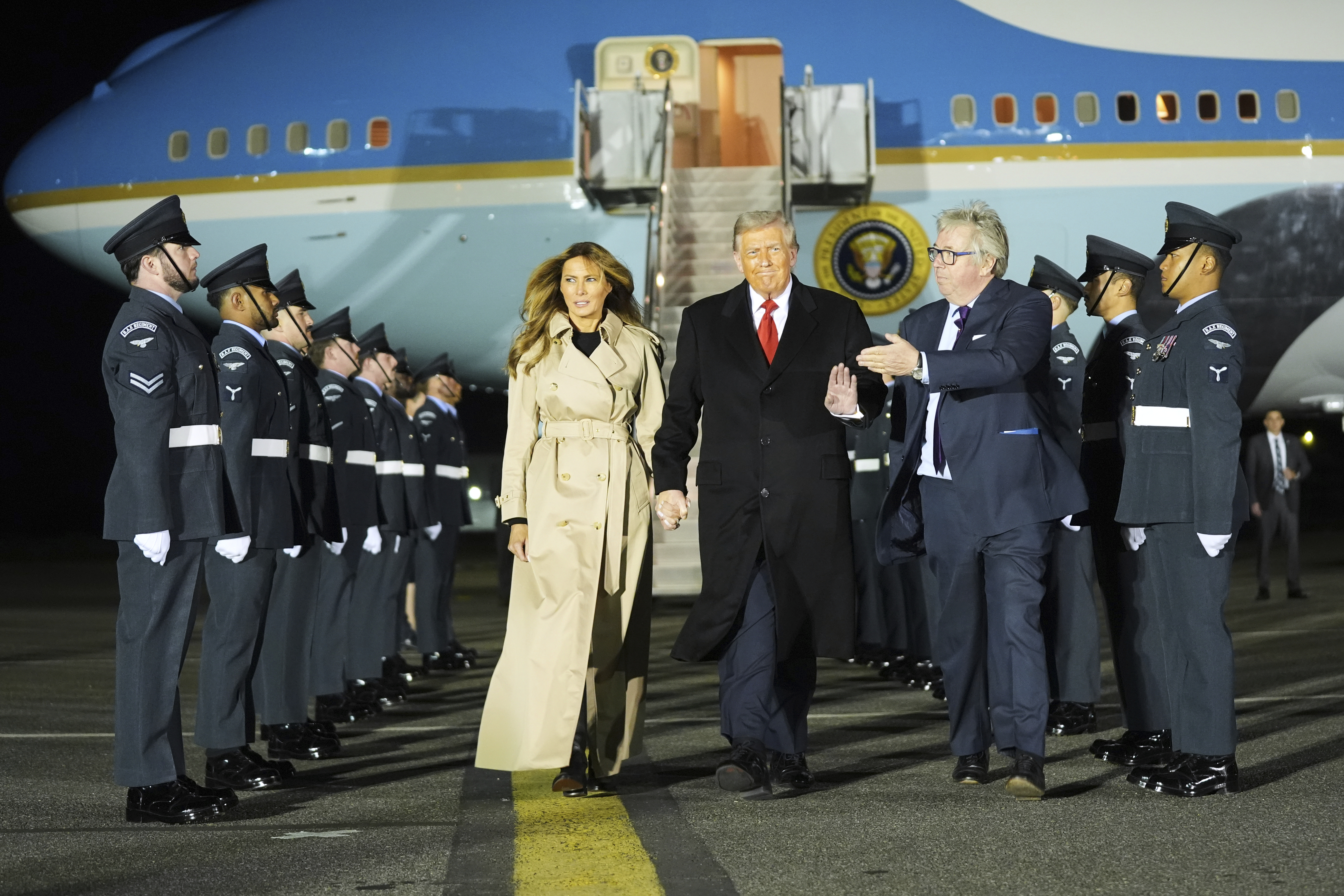 President Donald Trump and first lady Melania Trump are greeted by The Viscount Hood, Lord-in-Waiting, center, right, as they arrive at Stansted Airport near London