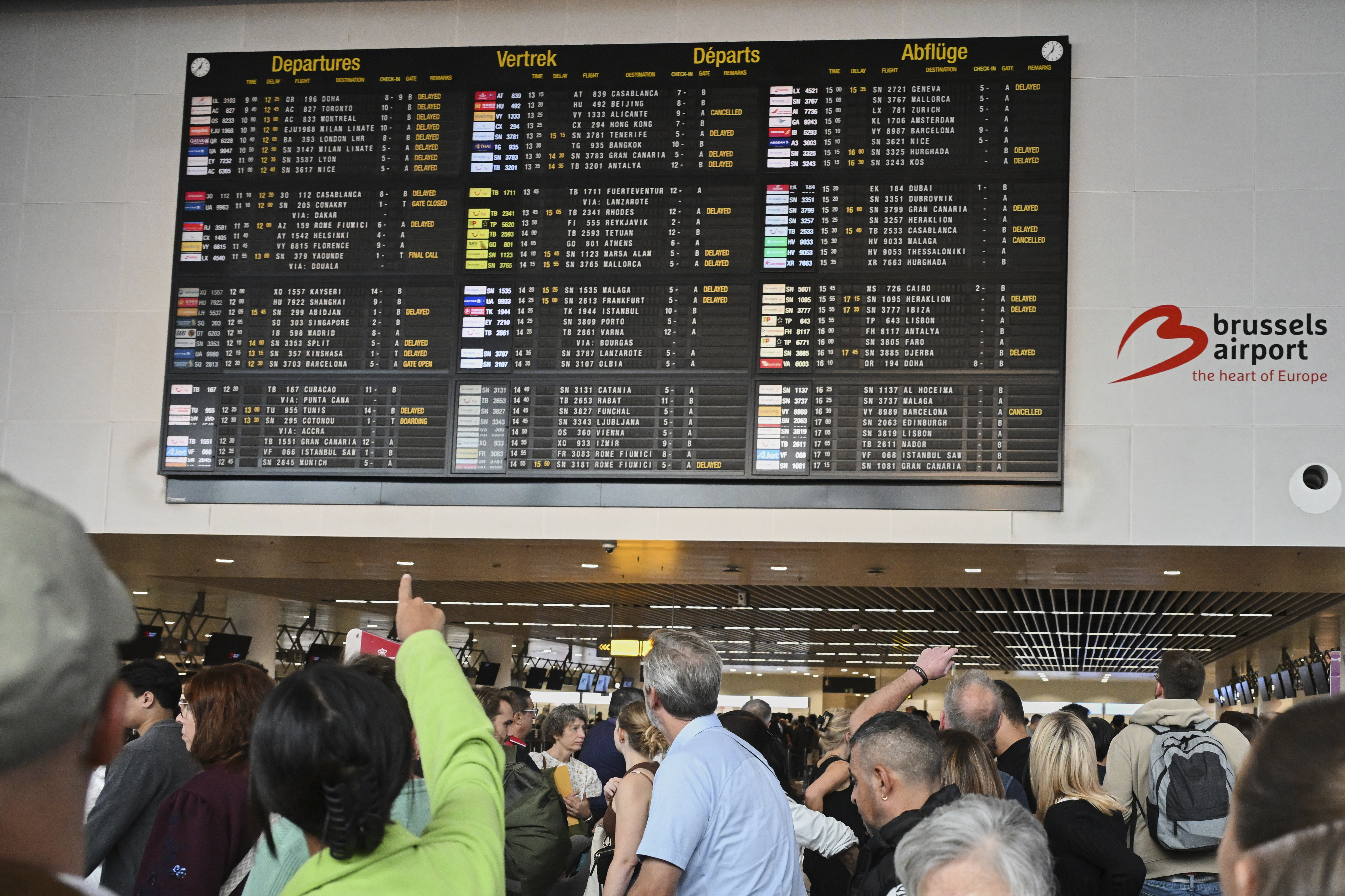 An airport employee points at a departure board after a cyberattack caused delays at Brussels international airport in Zaventem, Belgium [Harry Nakos/AP]