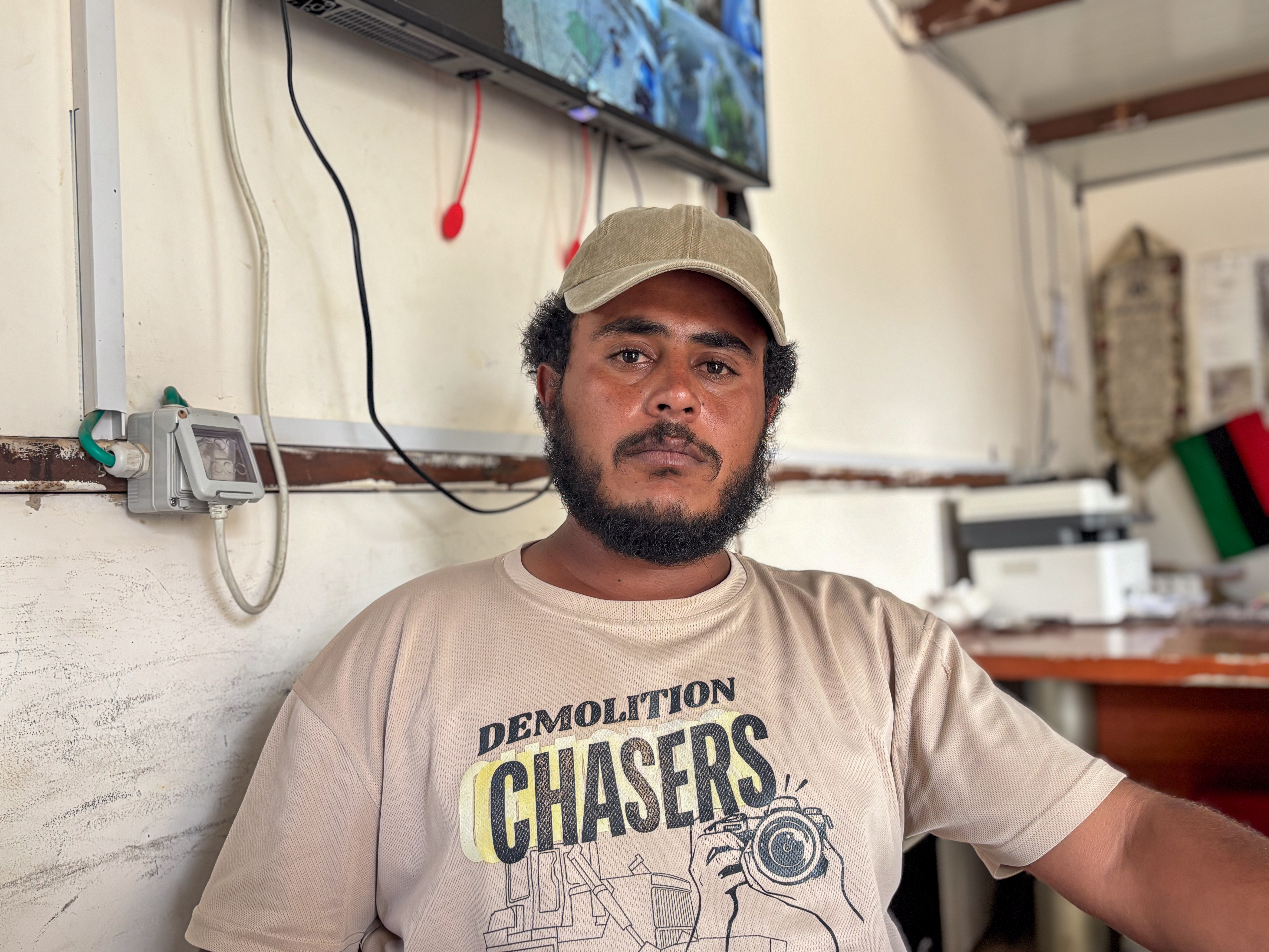 Tariq al-Hathaleen, wearing a beige cap and t-shirt, looks tearfully at the camera, still mourning the murder of Awdah
