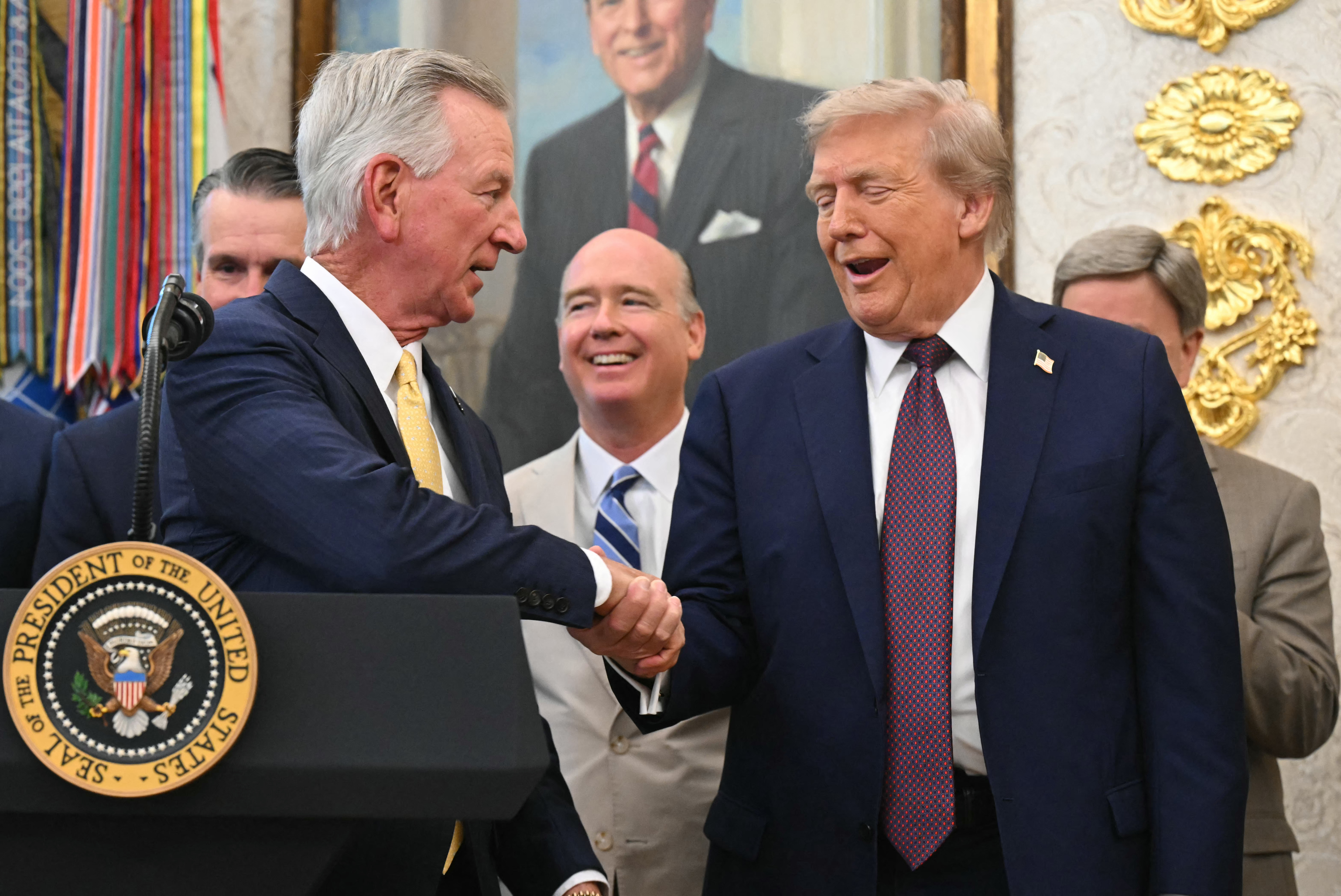 US President Donald Trump shakes hands with Alabama Senator Tommy Tuberville.
