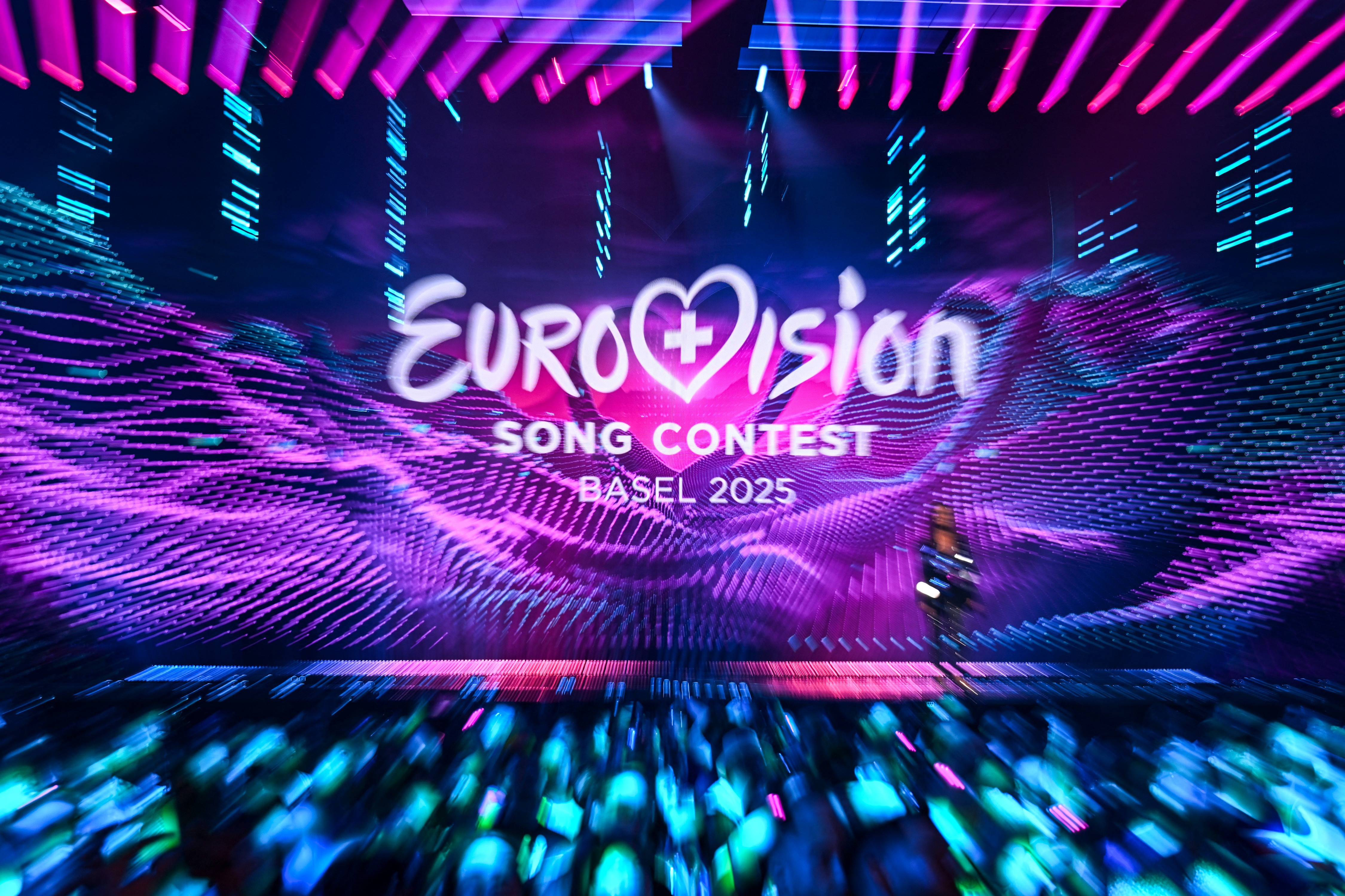 (FILES) This photograph shows the logo of the Eurovision Song Contest 2025 displayed on a screen at the end of the dress rehearsal for the second semi-final of the Eurovision Song Contest 2025 at the St. Jakobshalle arena in Basel on May 14, 2025.