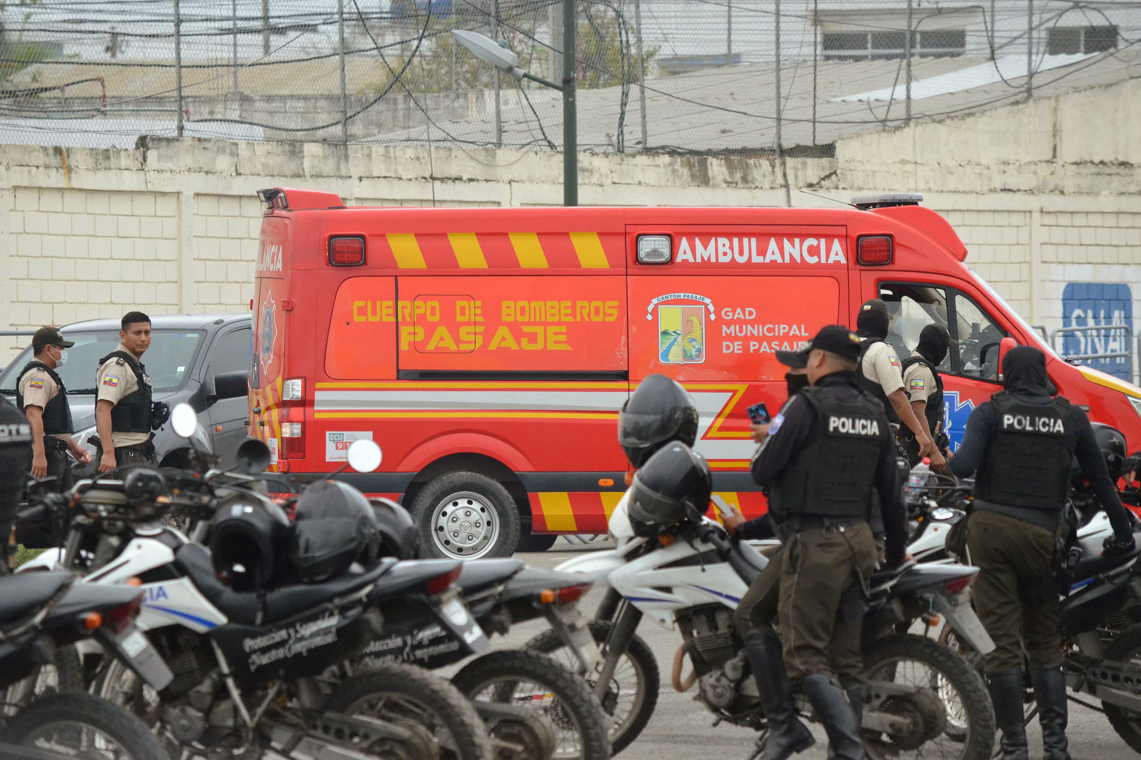 Police officers stand guard next to a fire department ambulance outside the main prison in Machala, Ecuador on September 22, 2025.
