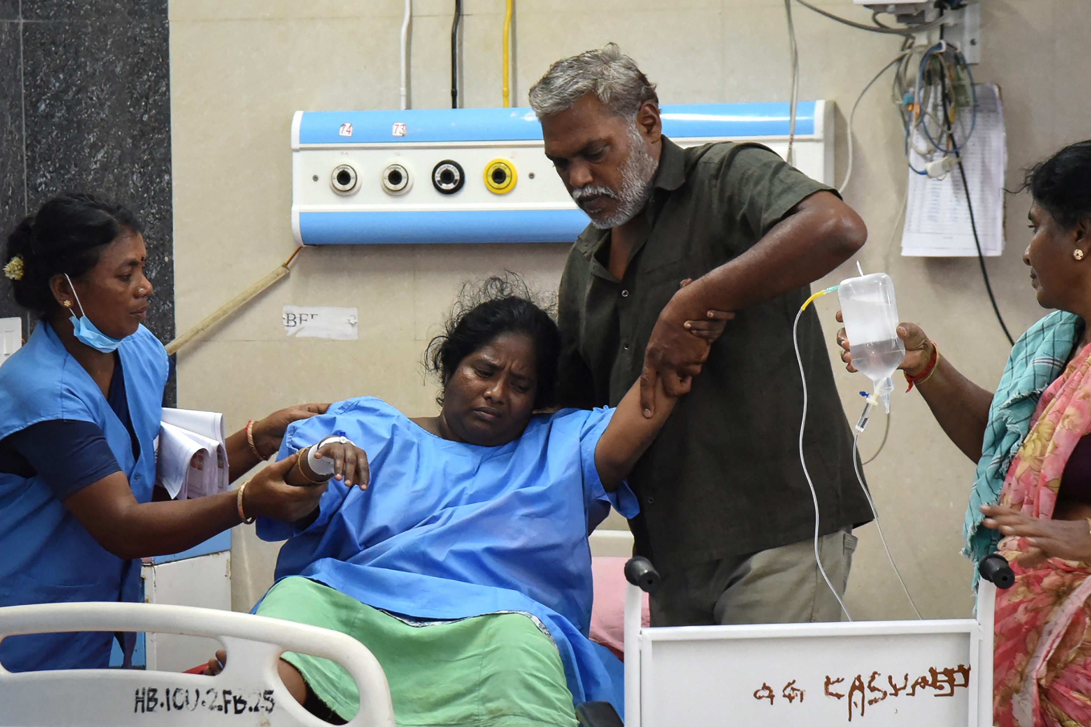 EDITORS NOTE: Graphic content / Relatives help a victim (2L) who is getting treatment at a hospital after a stampede broke out during a campaign rally last evening in the Karur district, in the Indian state of Tamil Nadu, on September 28, 2025.