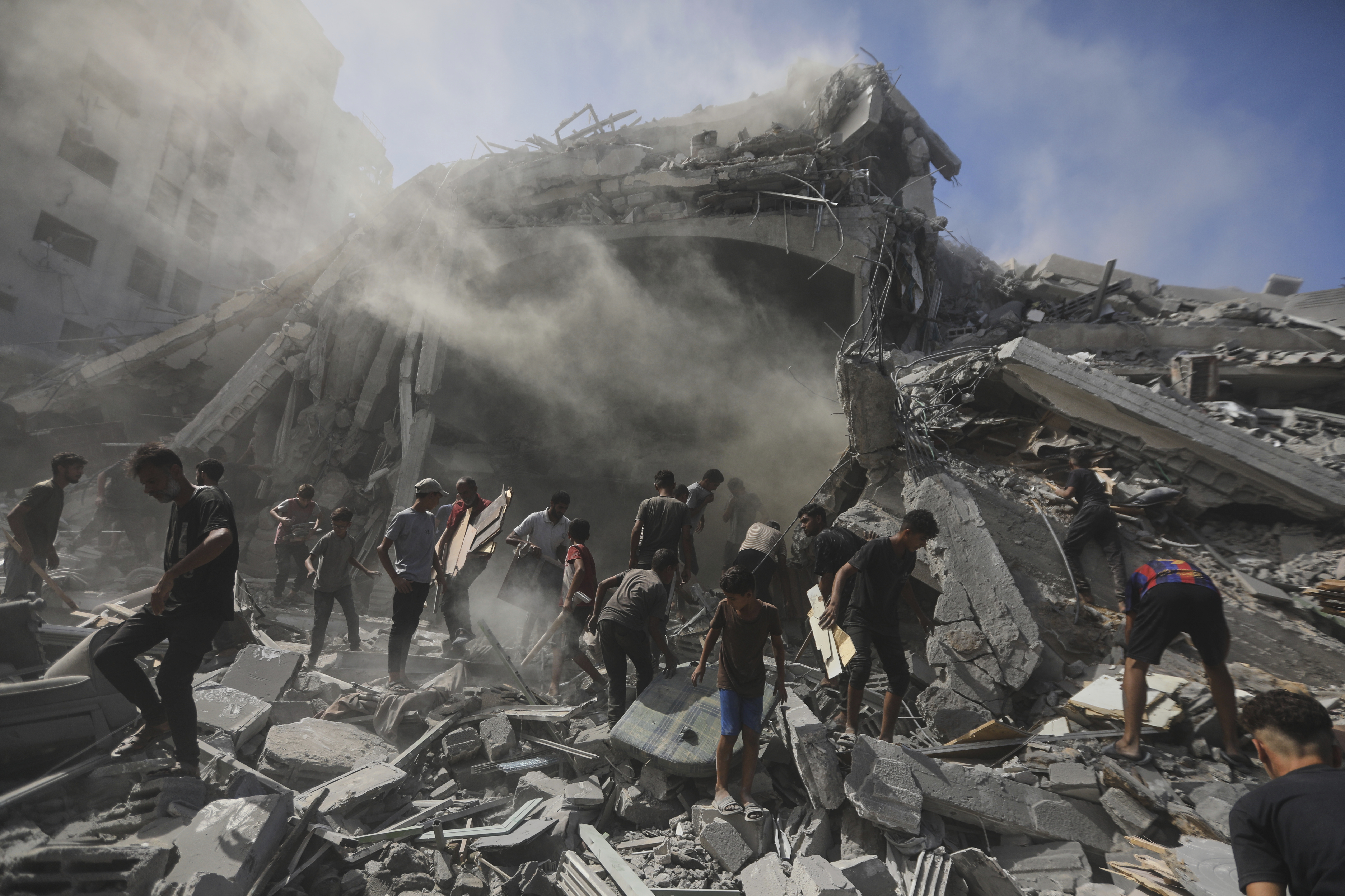 Palestinians search for wood to sell or use for cooking amid the rubble of a building from which thousands of artifacts were removed before being destroyed in an Israeli military strike in Gaza City, Sunday, Sept. 14, 2025. (AP Photo/Yousef Al Zanoun)