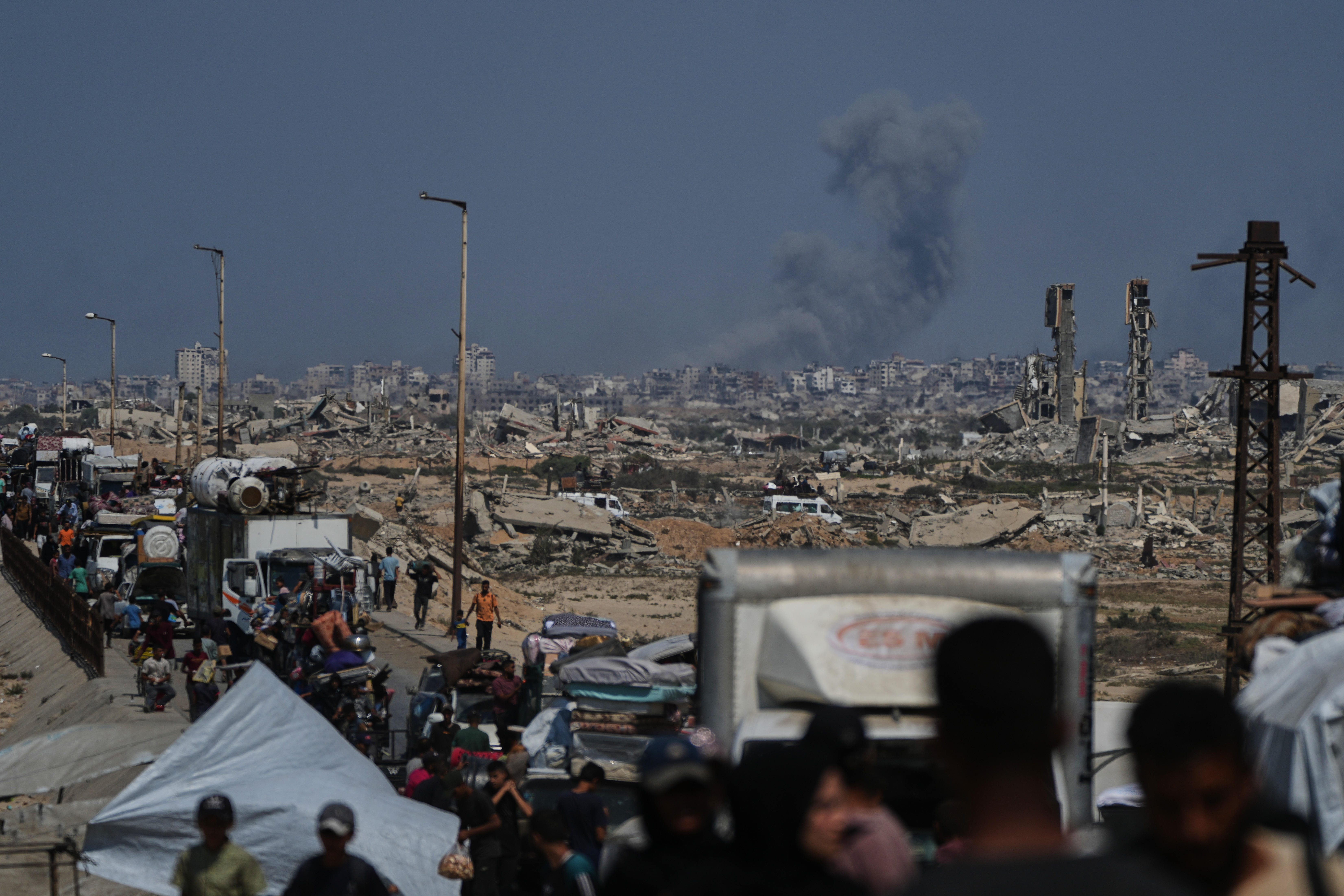 Smoke billows over Gaza City following an Israeli airstrike, as displaced Palestinians flee northern Gaza through Wadi Gaza, Wednesday, Sept. 24, 2025. (AP Photo/Abdel Kareem Hana)