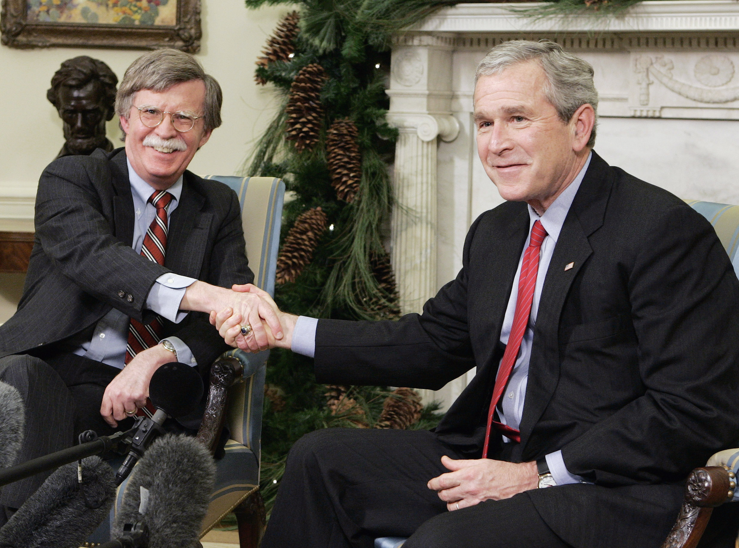 U.S. President George W. Bush (R) shakes hands with the U.S. Permanent Representative to the United Nations John Bolton
