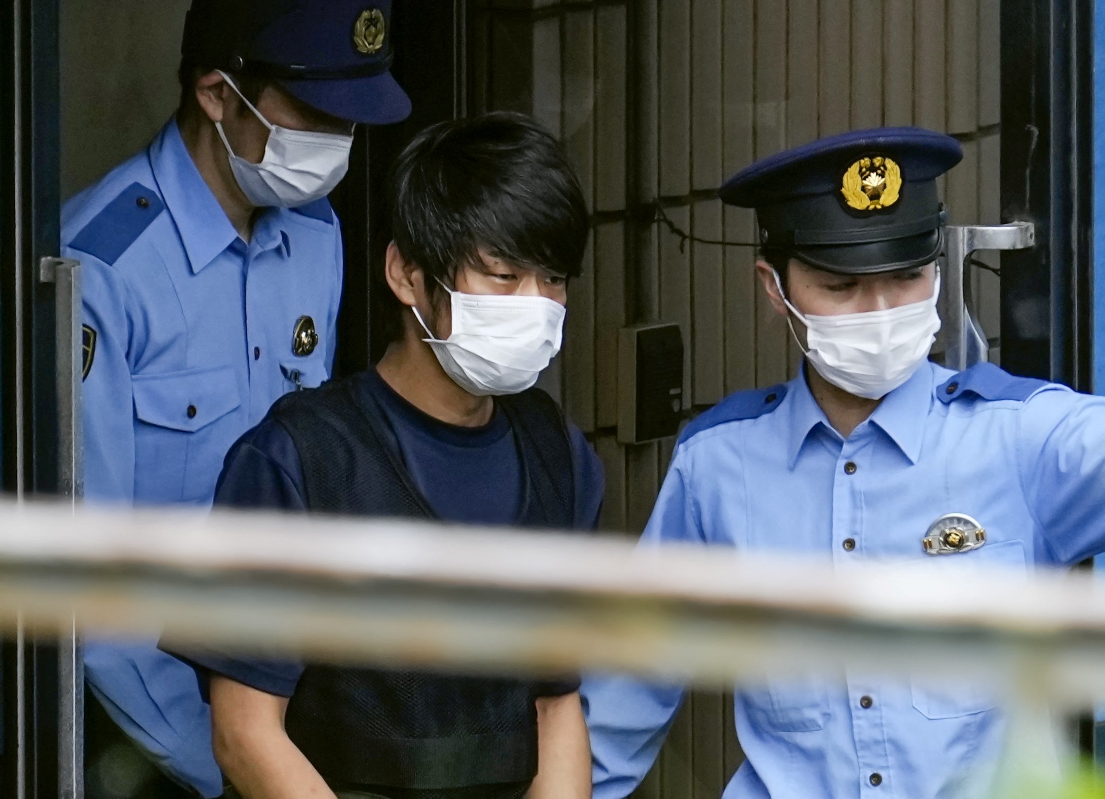 Tetsuya Yamagami, Suspected of killing former Japanese premier Shinzo Abe, is escorted by police officers as he is taken to prosecutors, at Nara-nishi police station in Nara, western Japan, in this photo taken by Kyodo July 10, 2022. Mandatory credit Kyodo via REUTERS ATTENTION EDITORS - THIS IMAGE WAS PROVIDED BY A THIRD PARTY. MANDATORY CREDIT. JAPAN OUT. NO COMMERCIAL OR EDITORIAL SALES IN JAPAN.