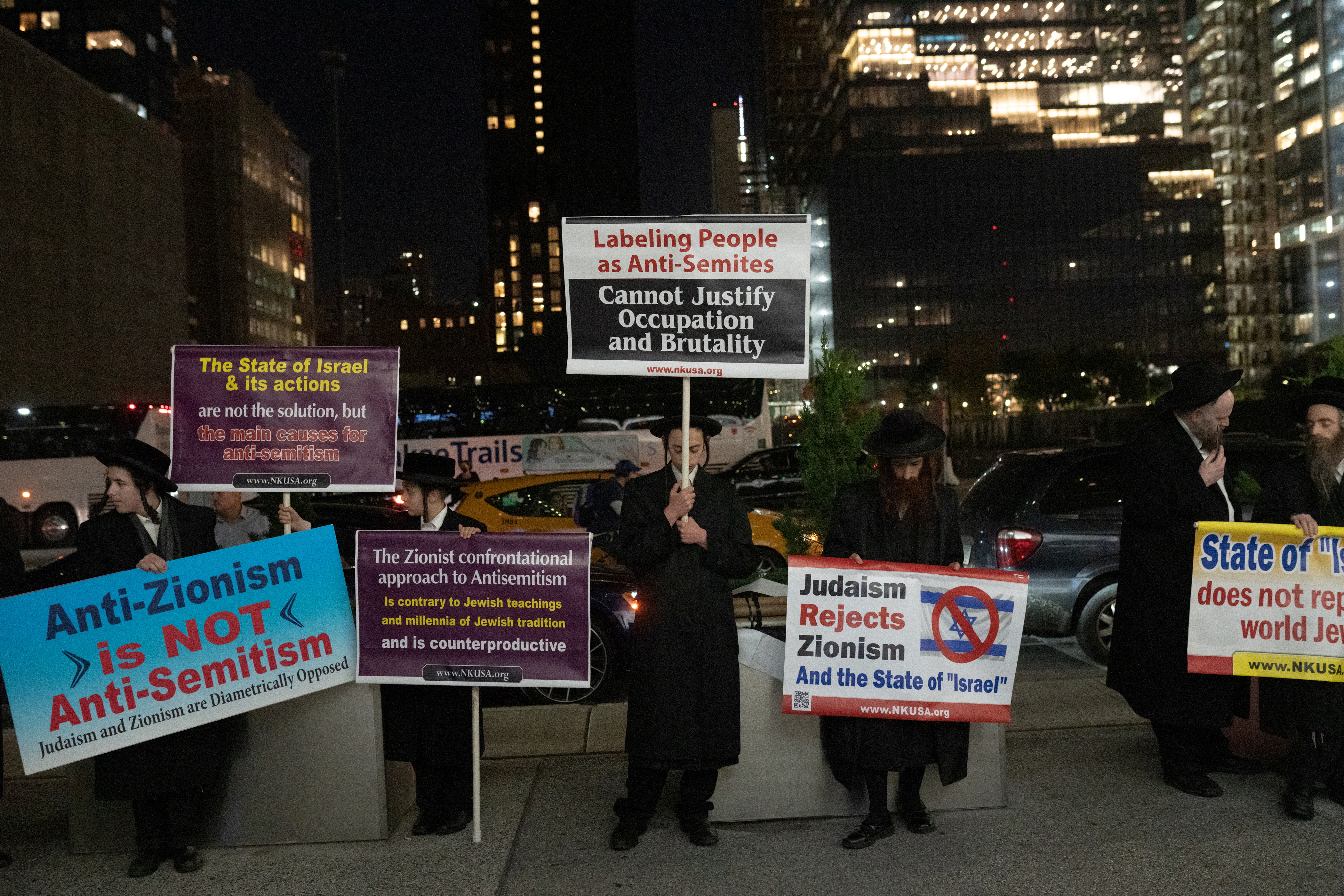 Protesters hold signs during the Anti-Defamation League's "Never is Now" summit outside the Jacob Javits Convention Center in Manhattan in New York City, New York, U.S., November 10, 2022. REUTERS/Jeenah Moon