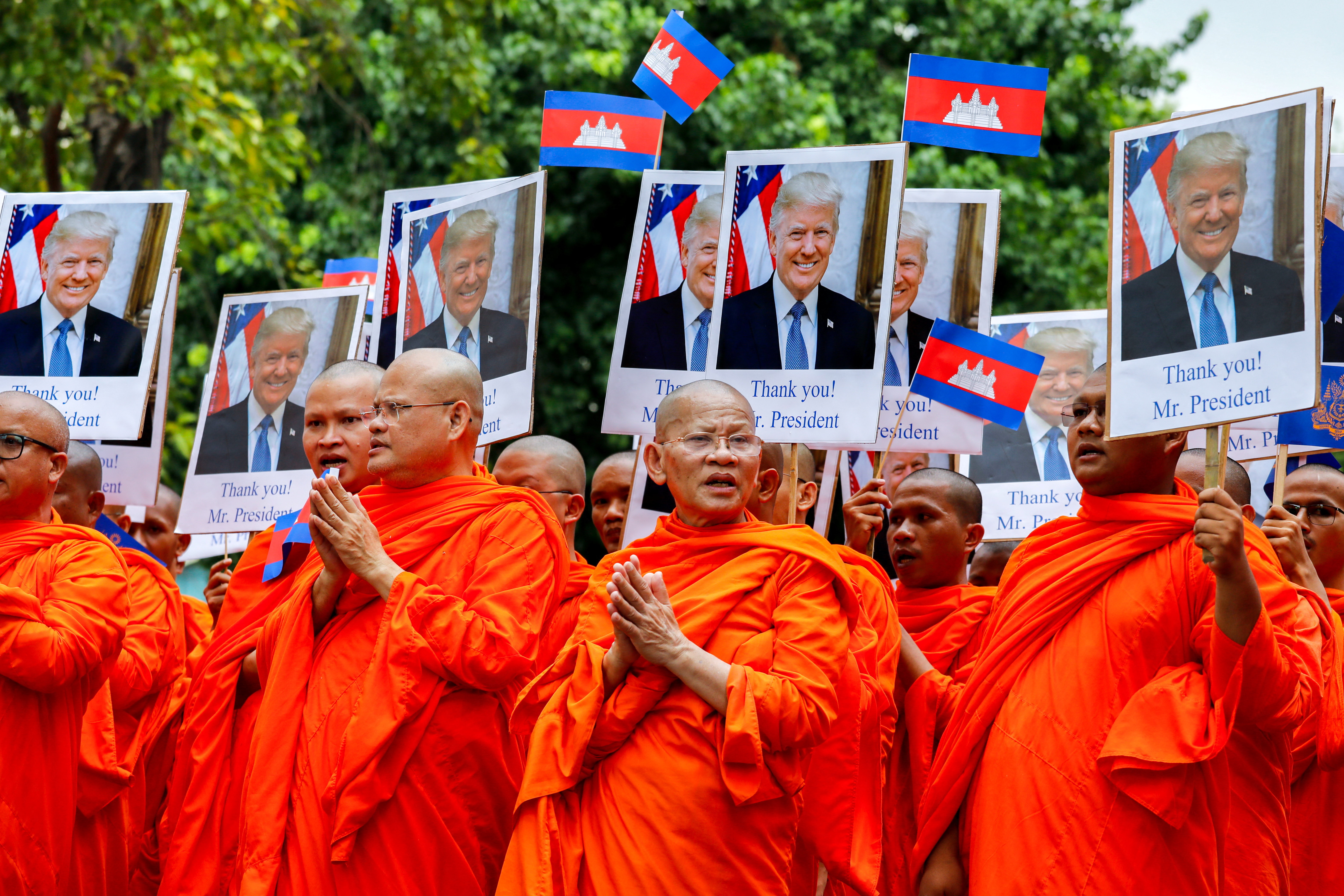 Buddhist monks hold portraits of US President Donald Trump during a march.