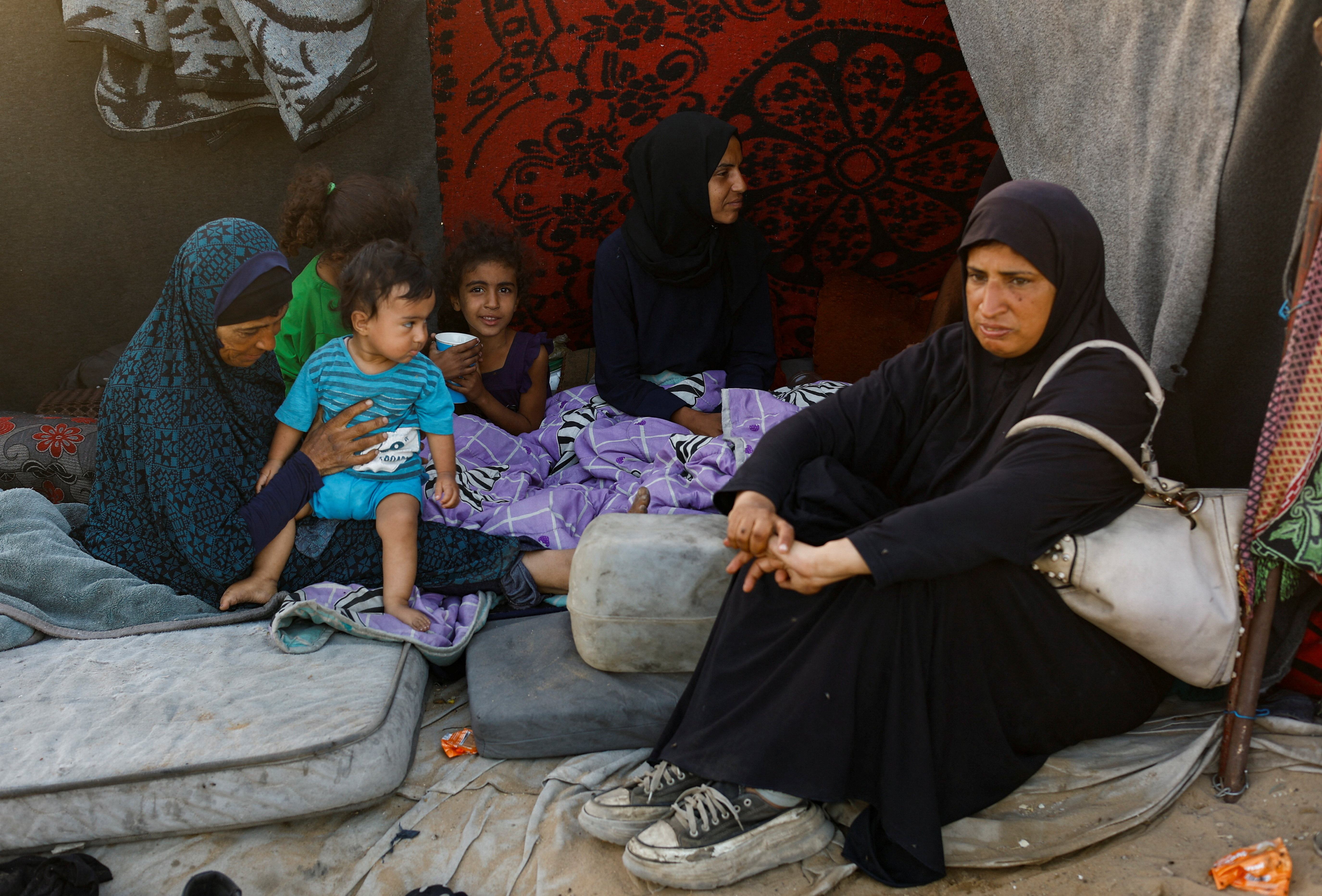 Displaced Palestinians from northern Gaza due to an Israeli military operation, rest after evacuating southwards, following Israeli forces' orders to leave Gaza City, in the central Gaza Strip, October 3, 2025. REUTERS/Mahmoud Issa