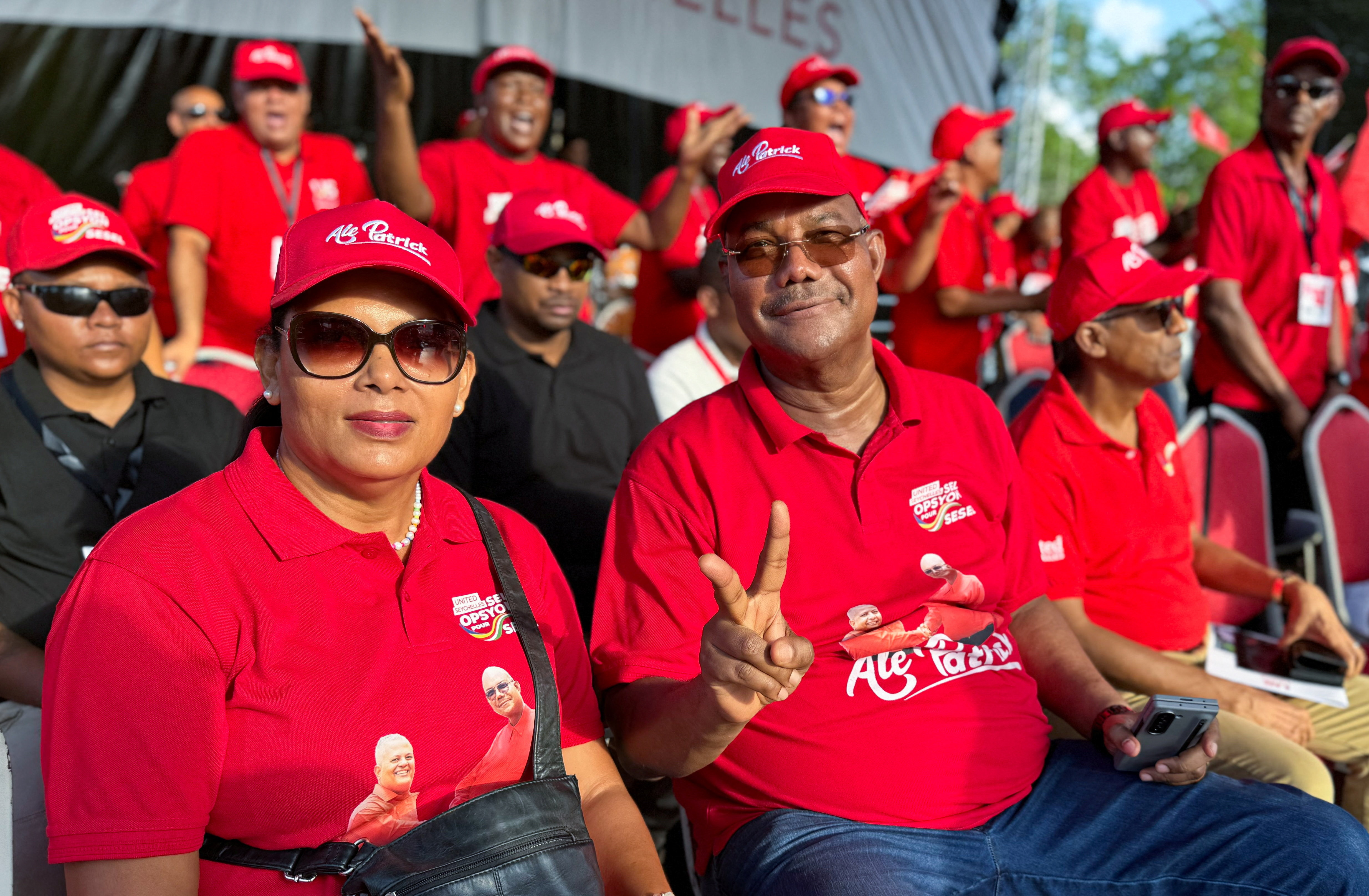Seychelles opposition leader of the United Seychelles (US) party and presidential candidate Patrick Herminie, flanked by his wife Veronique, flashes a two finger salute during his final rally ahead of the presidential runoff election, after no candidate secured the required 50% majority in the first round held on September 27, in Victoria, Seychelles, October 5, 2025. REUTERS/Gabriel Robert-Gironcelle