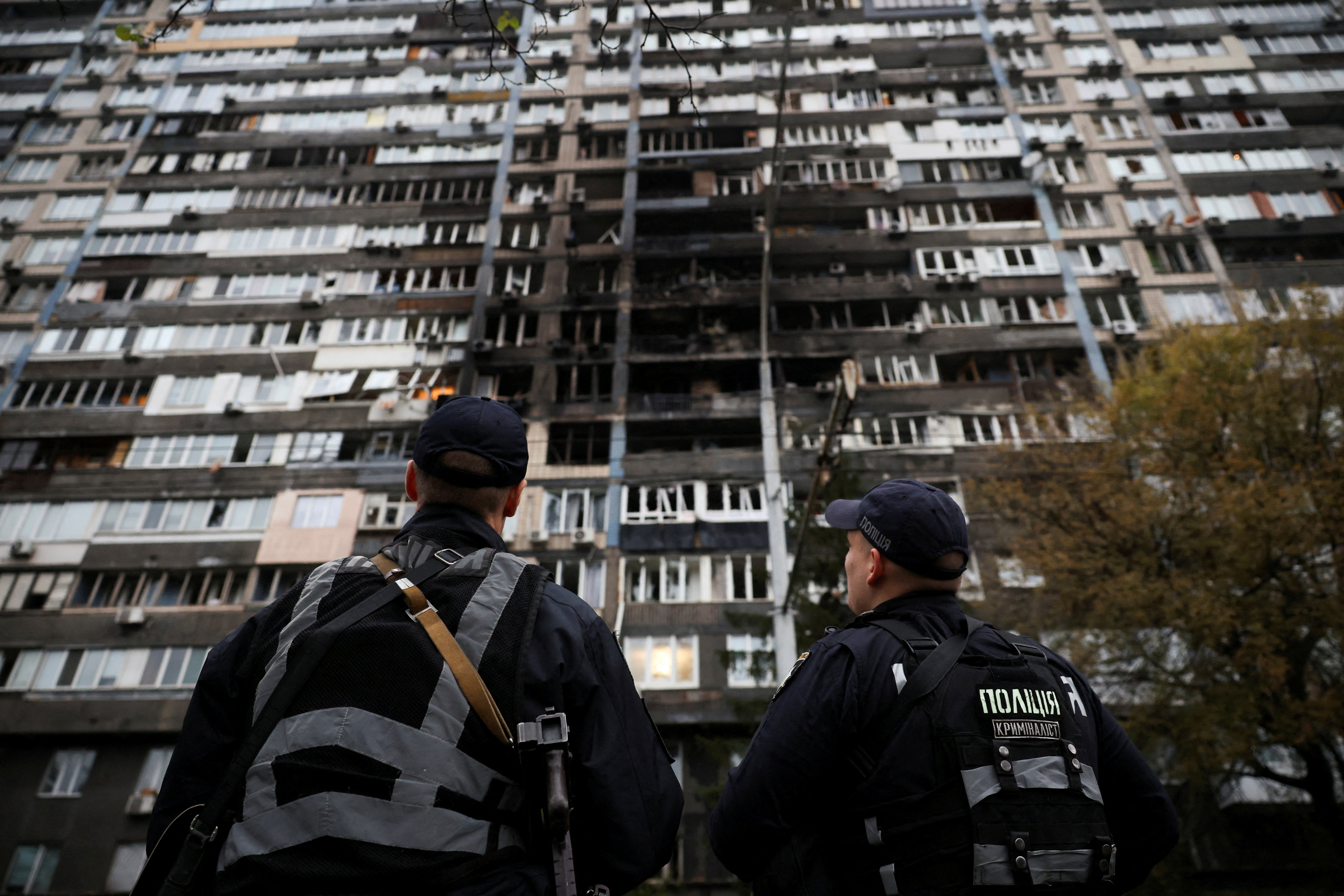 Police investigators look at an apartment building that was damaged during a Russian drone and missile strike, amid Russia's attack on Ukraine, in Kyiv, October 10, 2025. REUTERS/Thomas Peter TPX IMAGES OF THE DAY