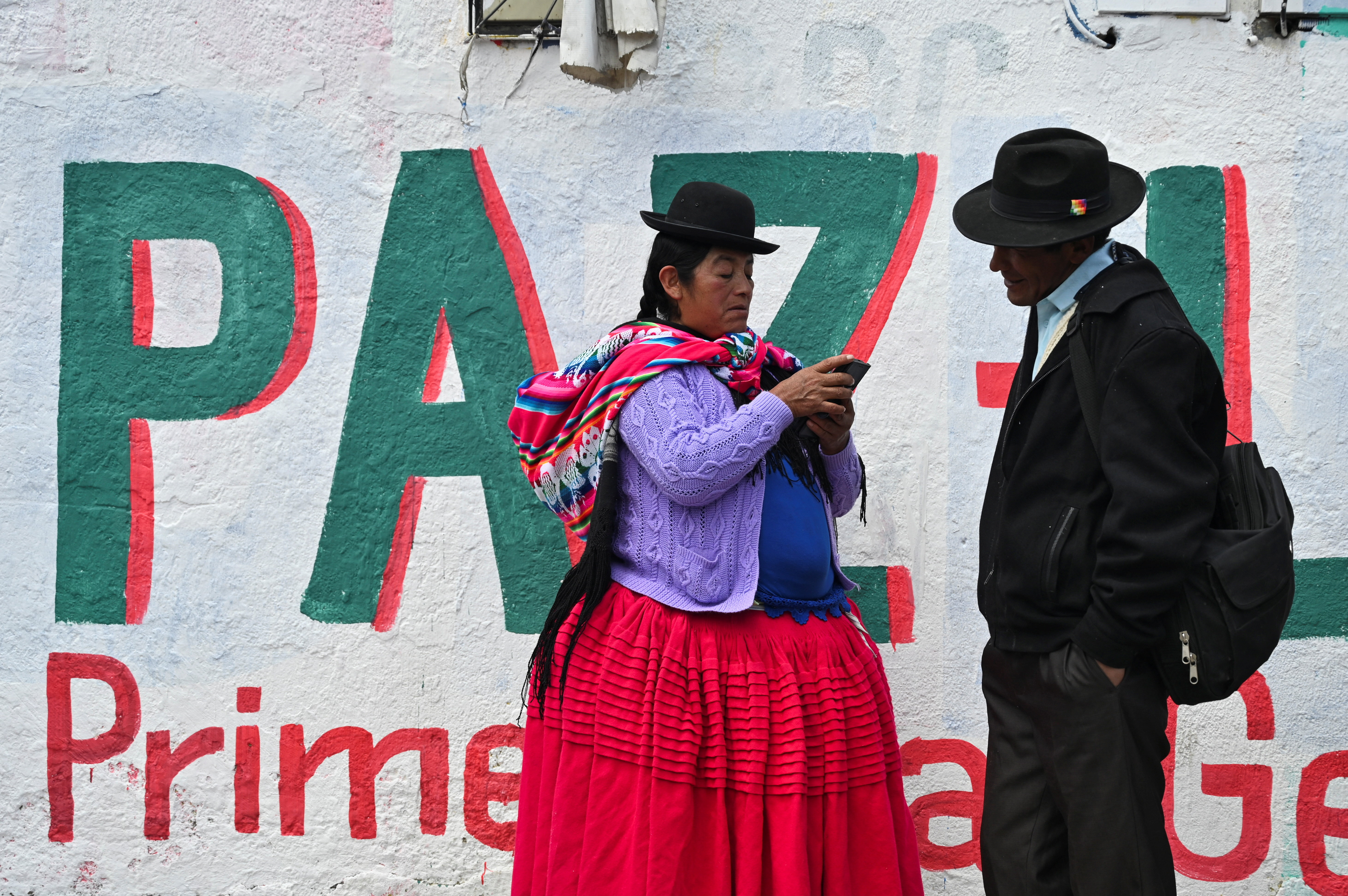 Supporters stand in front of a mural with Paz's name.