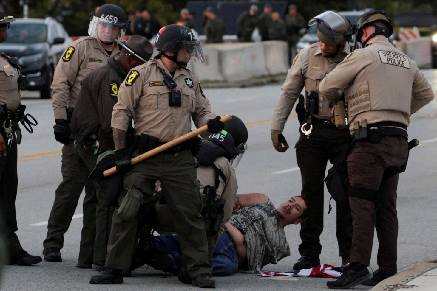 Law enforcement officers detain a demonstrator as people take part in a protest near the U.S. Immigration and Customs Enforcement (ICE) Broadview facility in Chicago, Illinois