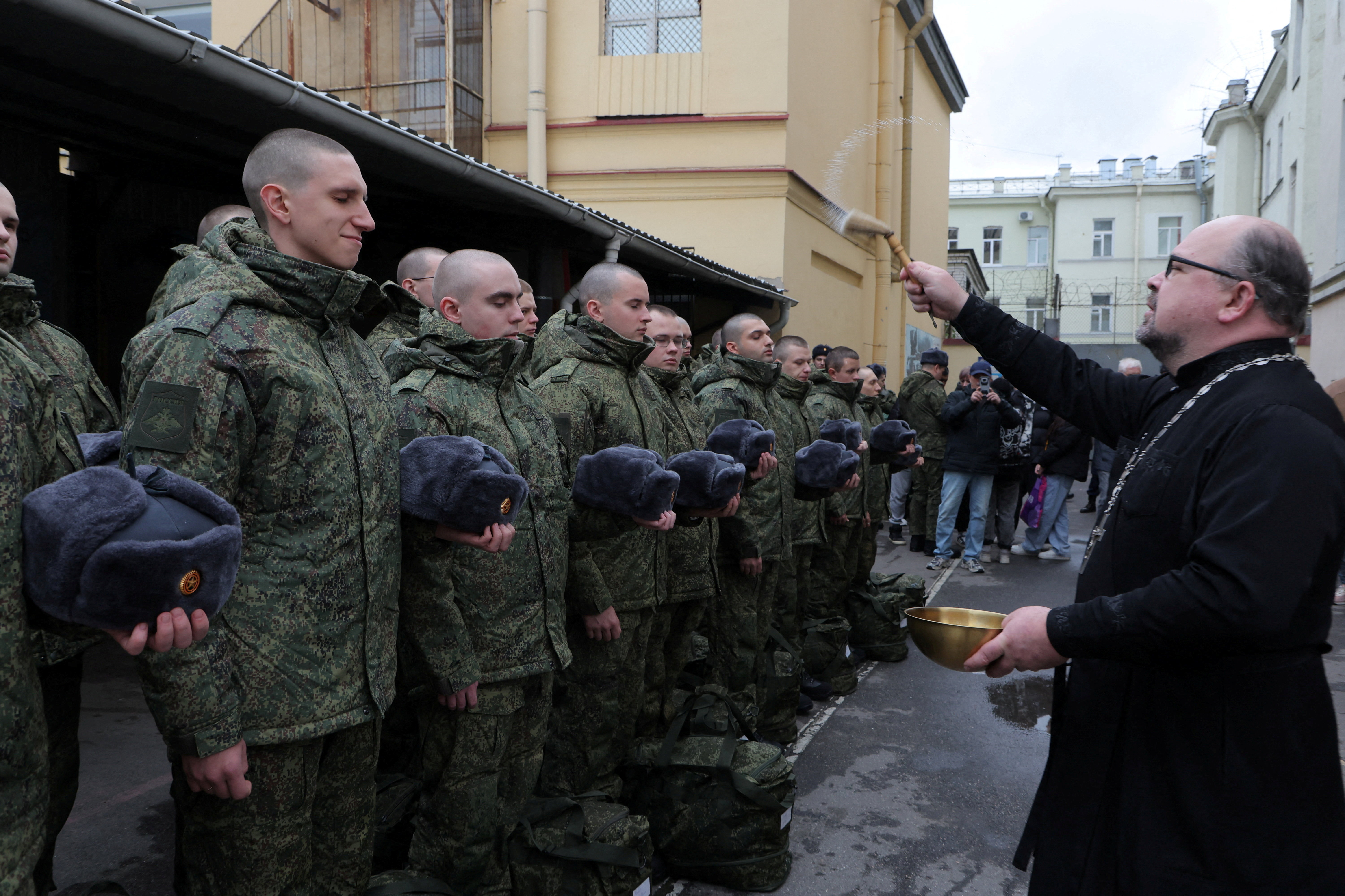 An Orthodox priest blesses Russian conscripts called up for military service during a ceremony marking the departure for garrisons from a recruitment centre in Saint Petersburg, Russia, October 15, 2025. REUTERS/Anton Vaganov TPX IMAGES OF THE DAY