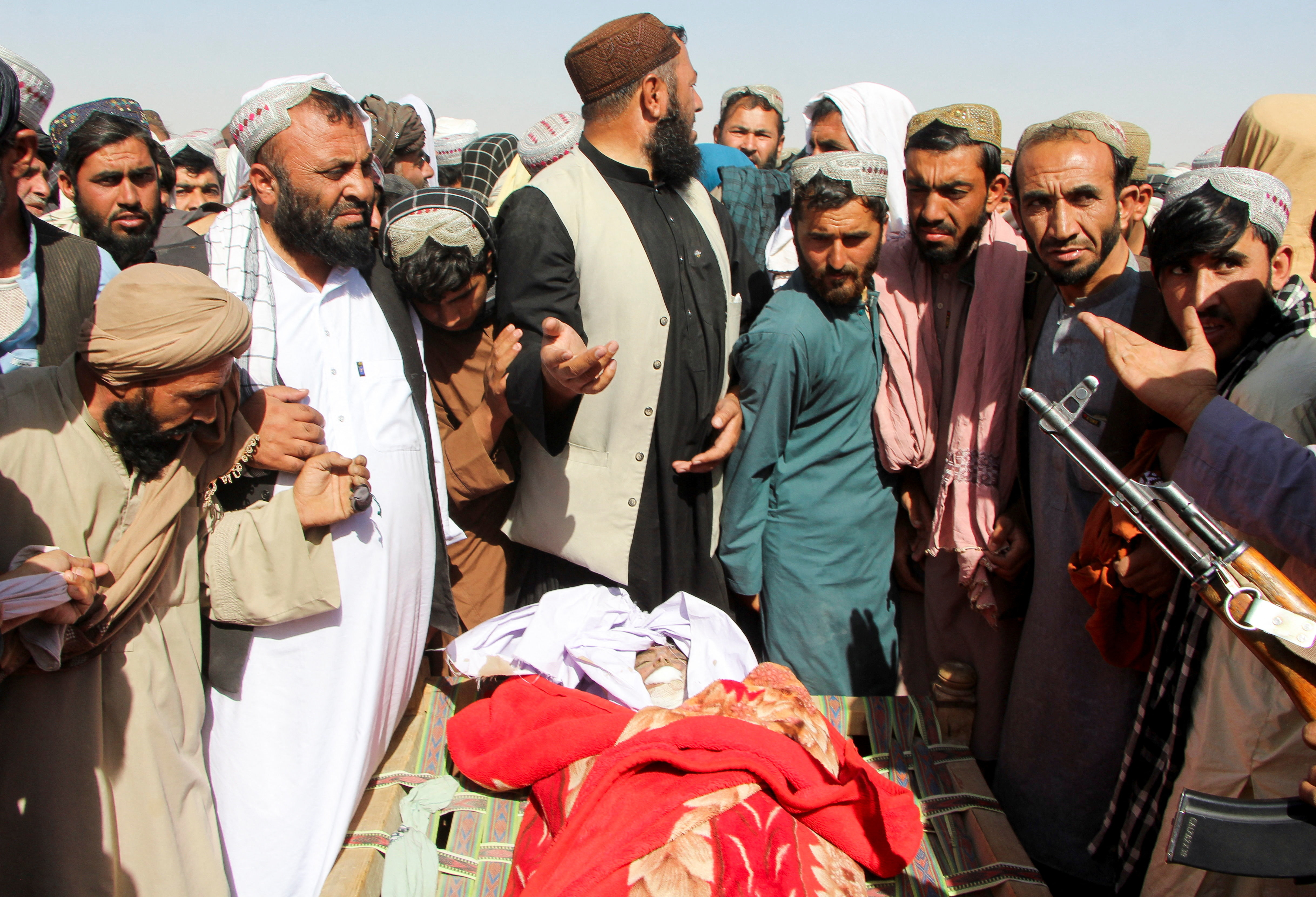 SENSITIVE MATERIAL. THIS IMAGE MAY OFFEND OR DISTURB People stand next to the body of a man killed during an airstrike, following a temporary ceasefire, amid the conflict between Afghanistan and Pakistan, in Spin Boldak district of Kandahar Province, Afghanistan, October 16, 2025. REUTERS/Stringer