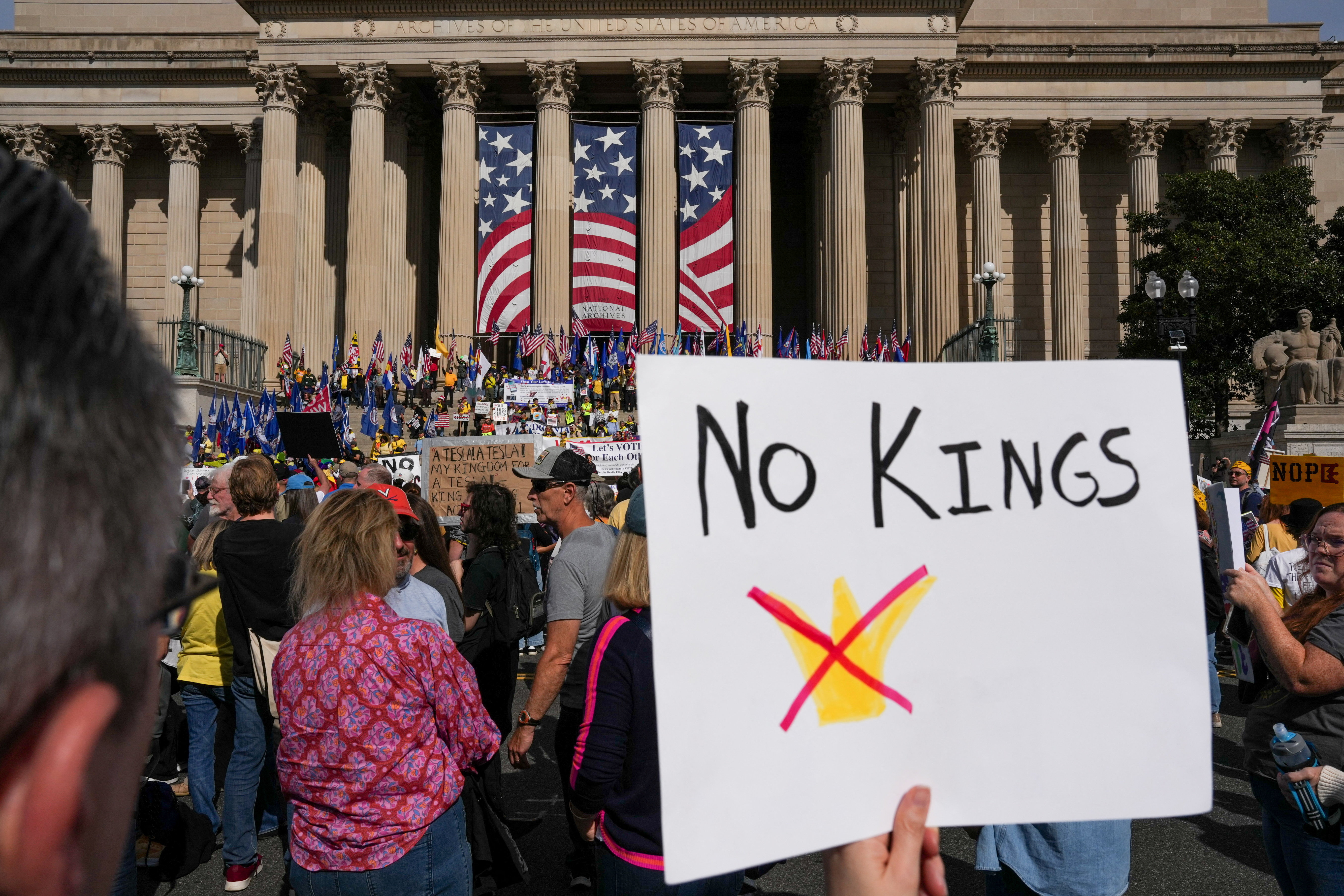 Demonstrators hold up a "No Kings" sign in a protest.