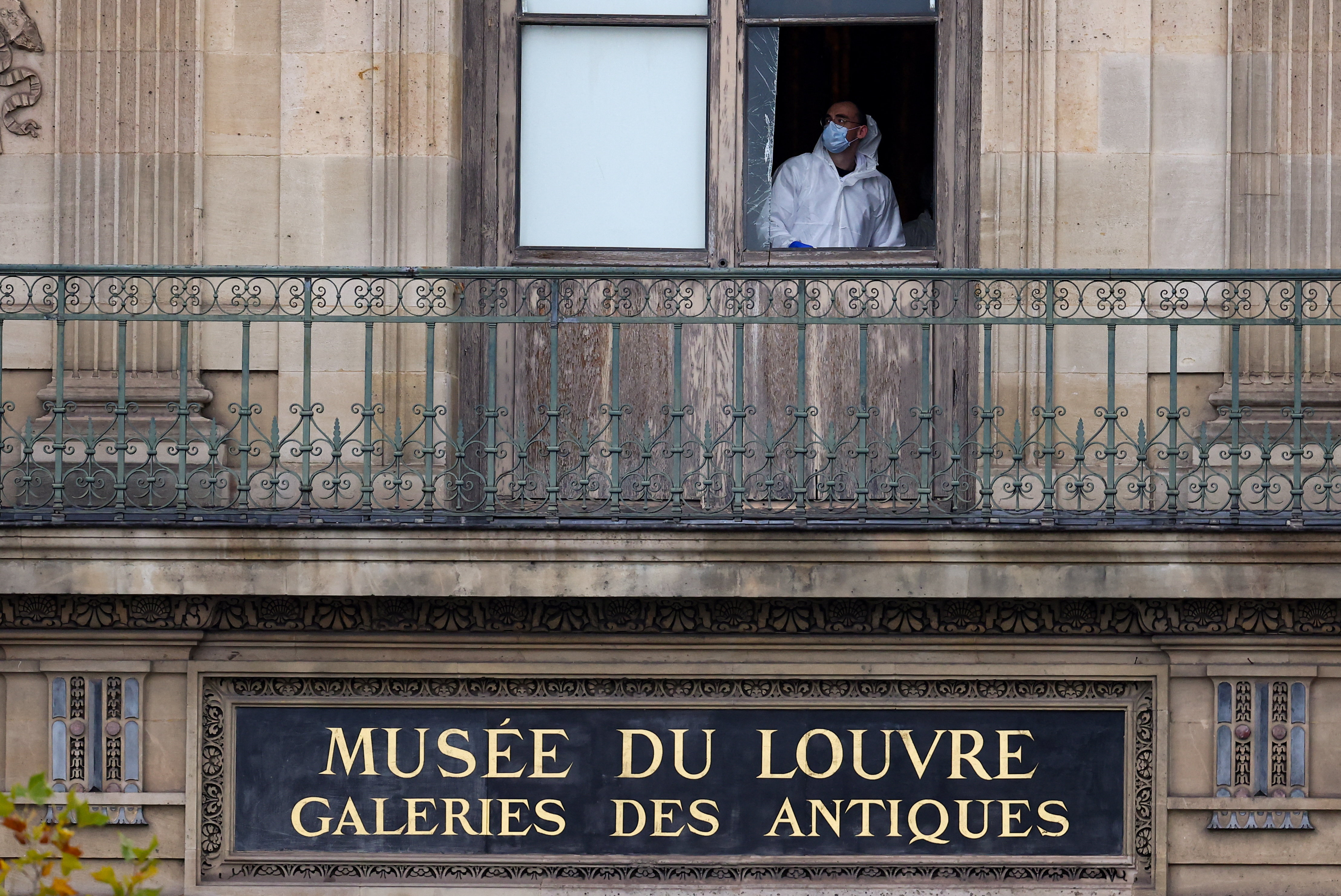 A member of a forensic team inspects a window believed to have been used in a robbery at the Louvre museum in Paris France on October 19, 2025.