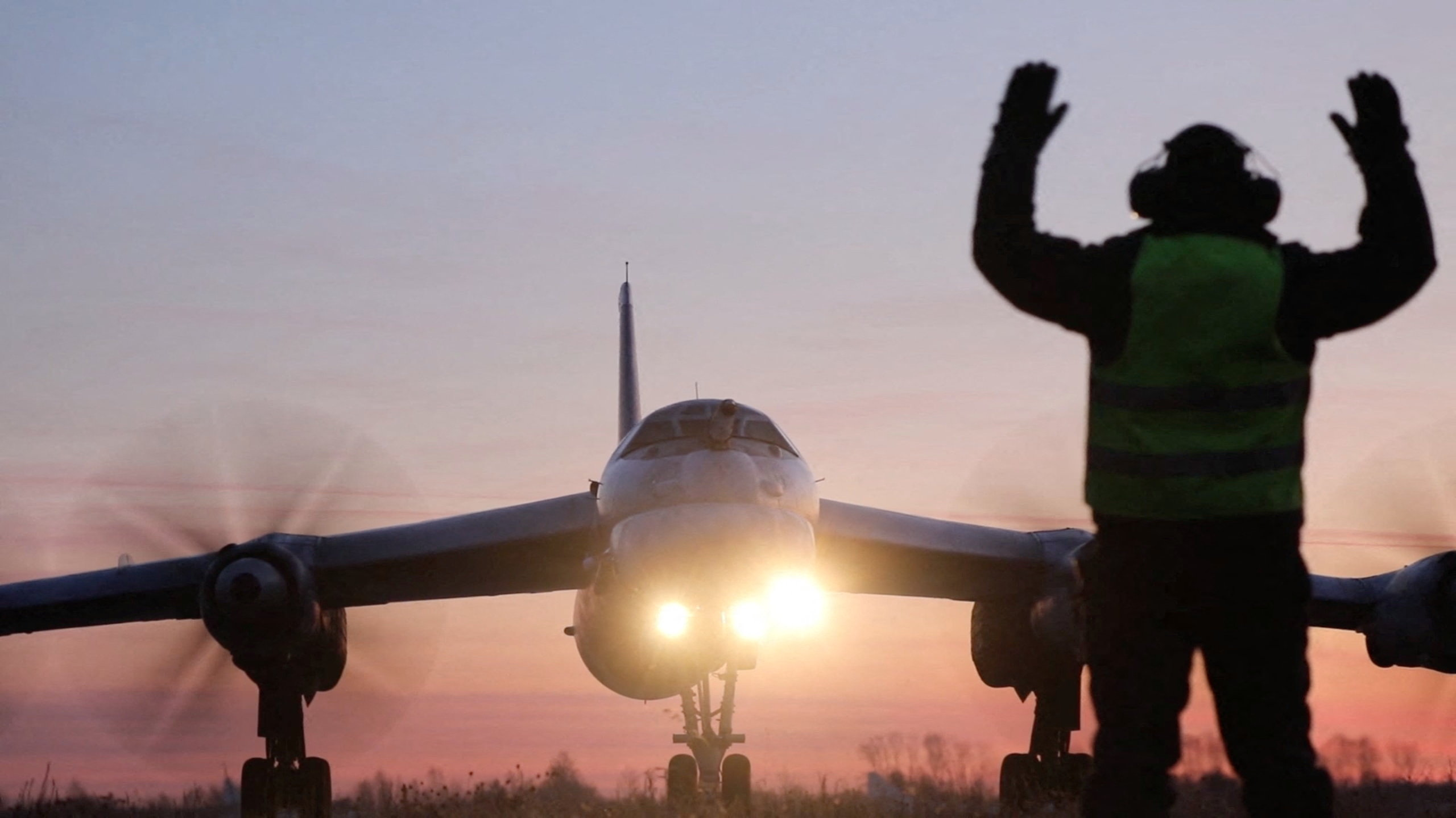 A ground crew marshaller guides a Russian Tu-95MS nuclear-capable strategic bomber performing a flight over neutral waters in the Sea of Japan, in this still image taken from a video released on October 24, 2025. Russian Defence Ministry/Handout via REUTERS ATTENTION EDITORS - THIS IMAGE HAS BEEN SUPPLIED BY A THIRD PARTY. NO RESALES. NO ARCHIVES. MANDATORY CREDIT