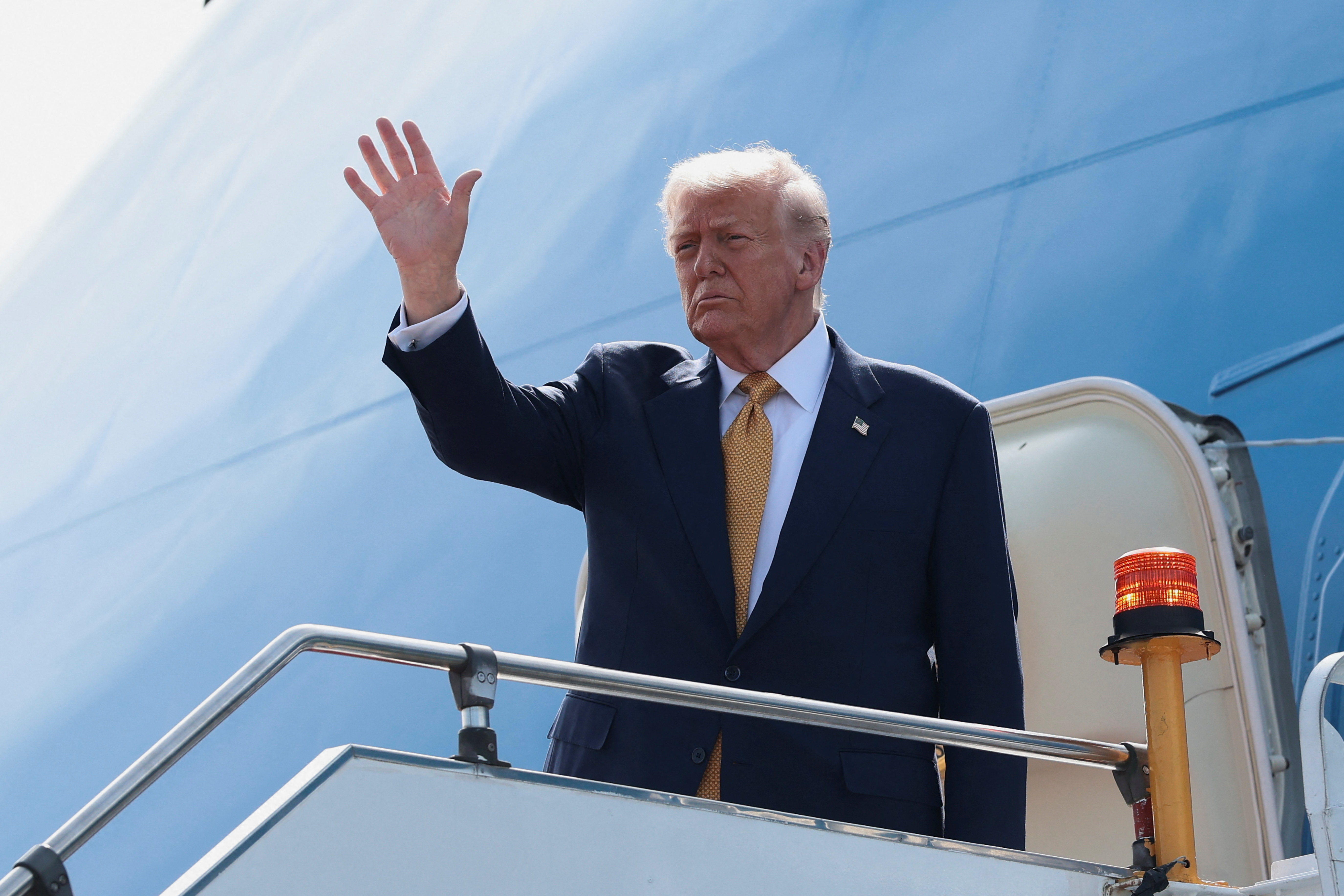 US President Donald Trump gestures while boarding Air Force One.