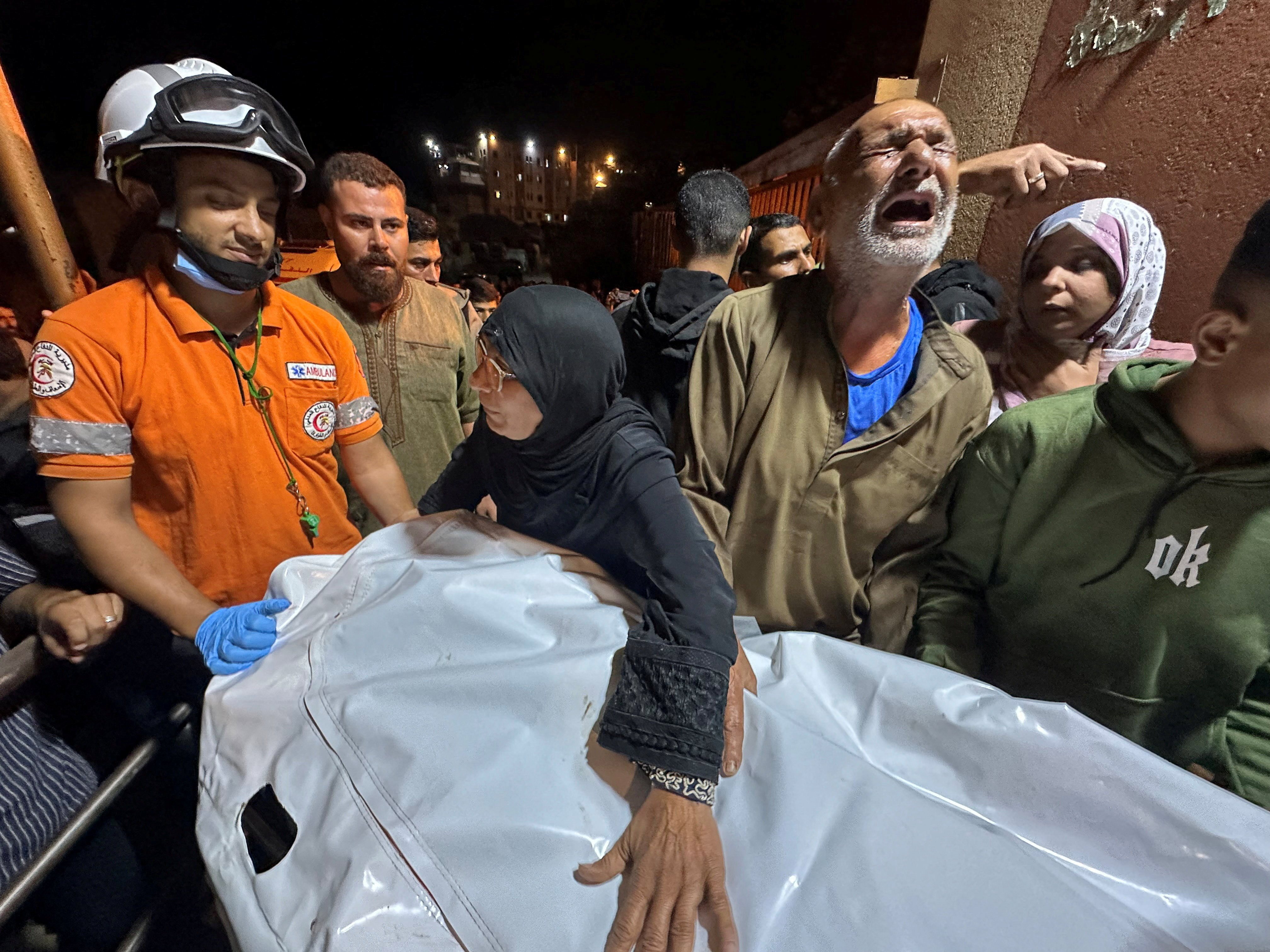 A Palestinian man reacts next to the body of a man, who according to medics was killed in an Israeli strike, at Nasser Hospital in Khan Younis, southern Gaza Strip, October 28, 2025. REUTERS/Stringer