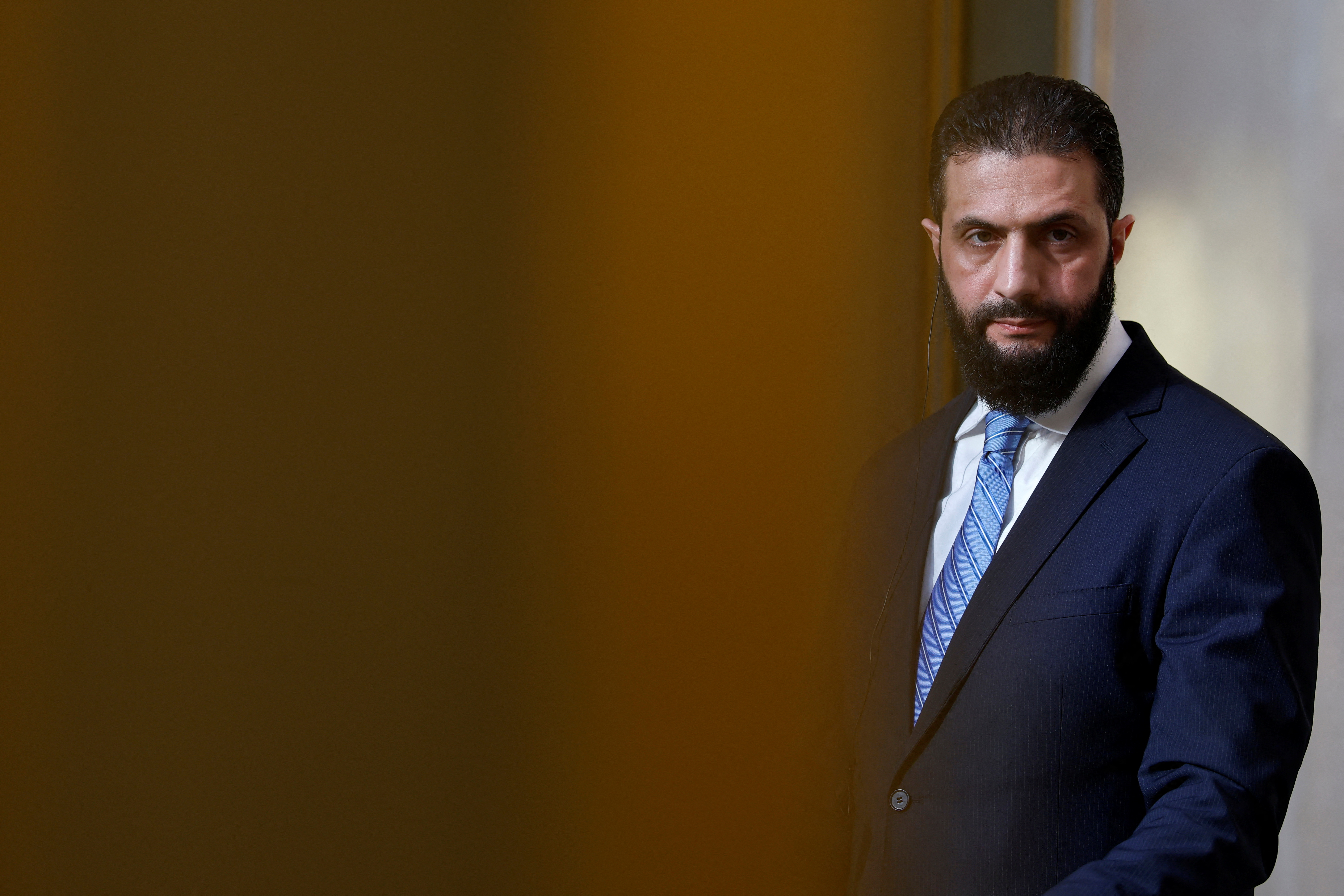 Syrian President Ahmed al-Sharaa listens to French President during a joint press conference after a meeting at the Elysee Palace in Paris, on May 7, 2025. Syrian interim President Ahmed al-Sharaa arrived in Paris on May 7, state media reported, on his first visit to Europe since overthrowing longtime ruler Bashar al-Assad in December. (Photo by Stephanie Lecocq / POOL / AFP)