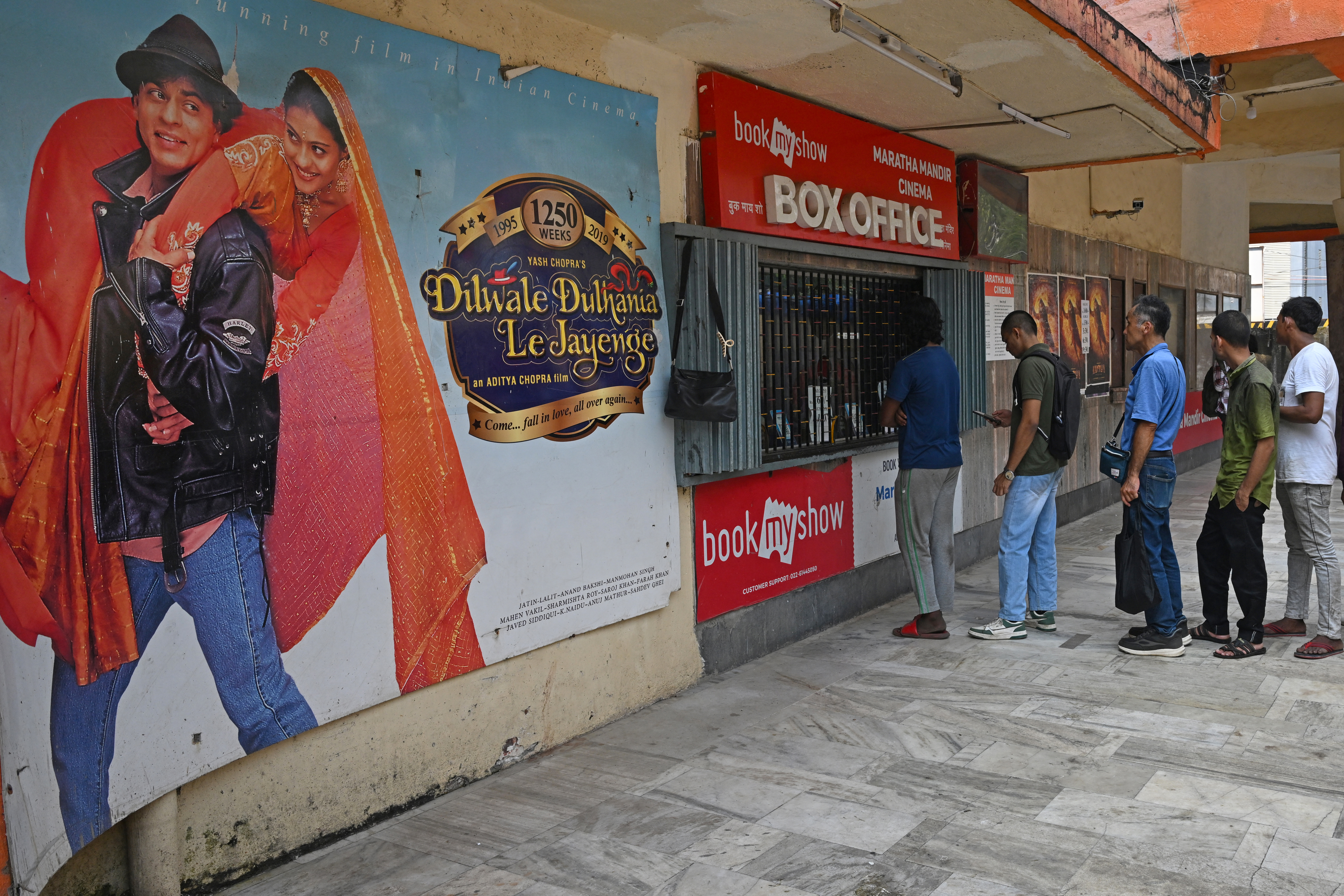 Moviegoers wait in a queue to buy tickets for the popular Hindi film Dilwale Dulhania Le Jayenge at Maratha Mandir theatre in Mumbai, India