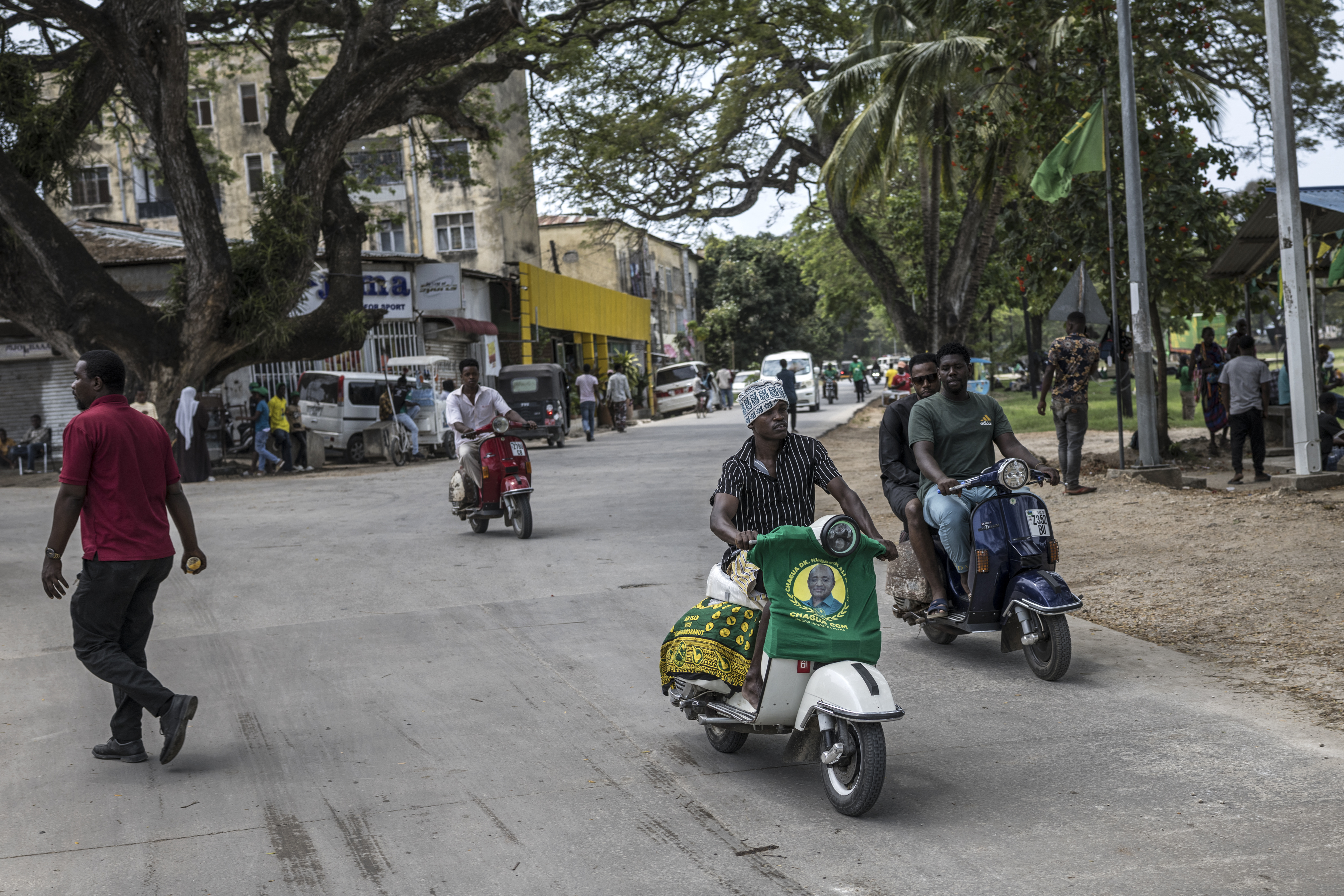 A supporter of the ruling Tanzanian Chama Cha Mapinduzi (CCM - Revolutionary Party) of the incumbent President Samia Suluhu Hassan steers his Vespa in Stone Town, on October 24, 2025. (Photo by MARCO LONGARI / AFP)