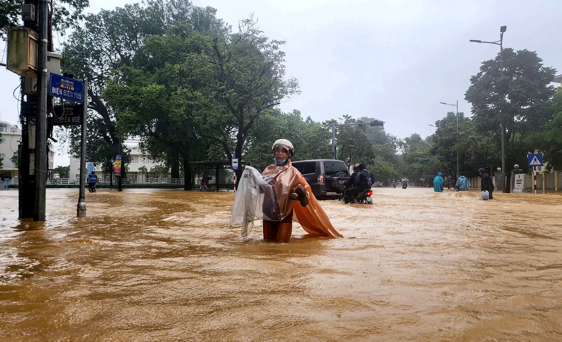 A woman wearing a raincoat wades through a flooded street in Hue on October 28, 2025.The central Vietnamese city of Hue recorded more than a metre of rainfall in a 24-hour period, smashing a national record set over two decades ago, the environment ministry said.