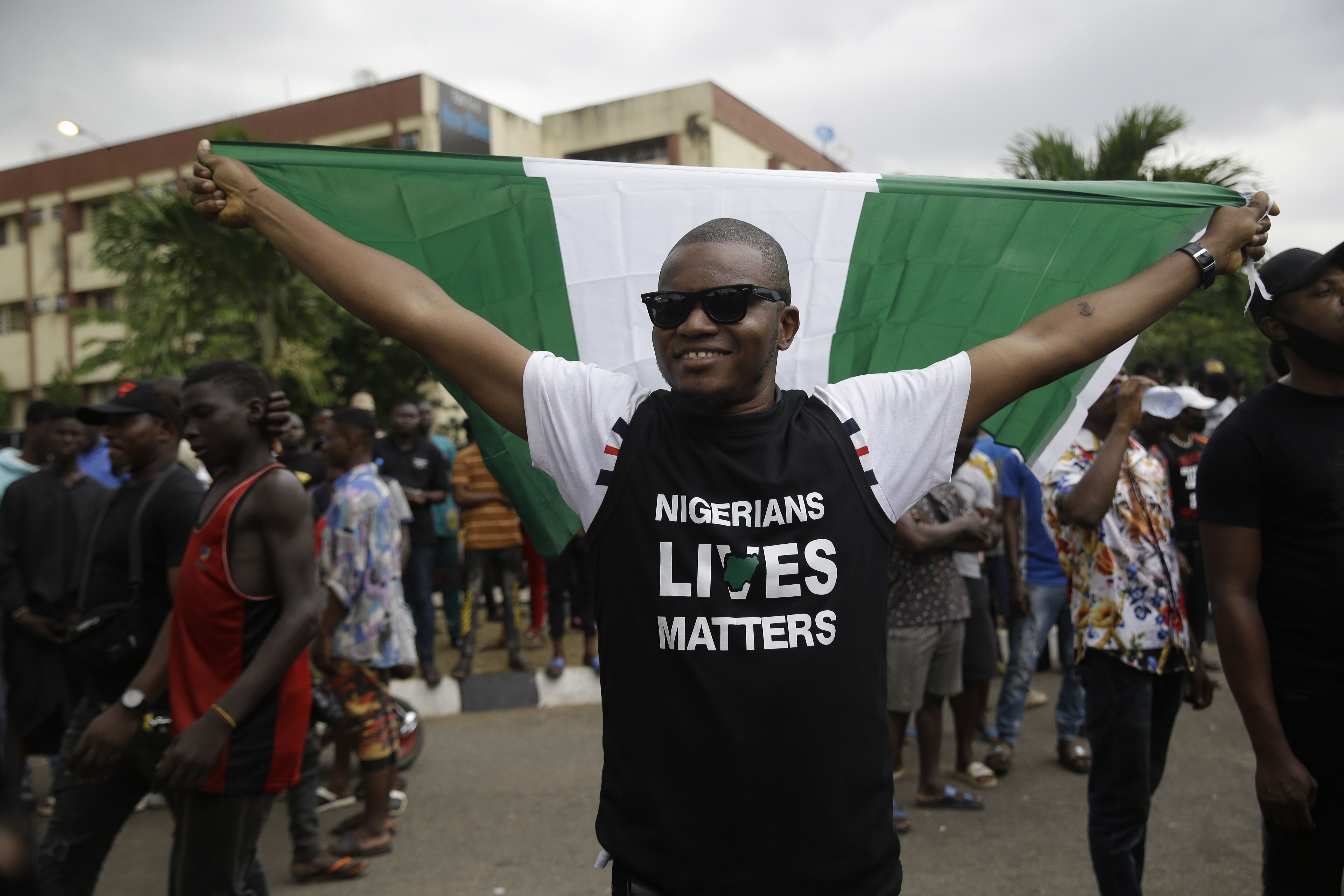 A man holds a Nigerian flag as he demonstrate on the street to protest against police brutality in Lagos, Nigeria, Friday Oct. 16, 2020. Nigerian protests against police brutality continued Friday for the ninth day, with demonstrators fending off attacks from gangs suspected to be backed by the police, warnings from the Nigerian military, and a government order to stop because of COVID-19. (AP Photo/Sunday Alamba)