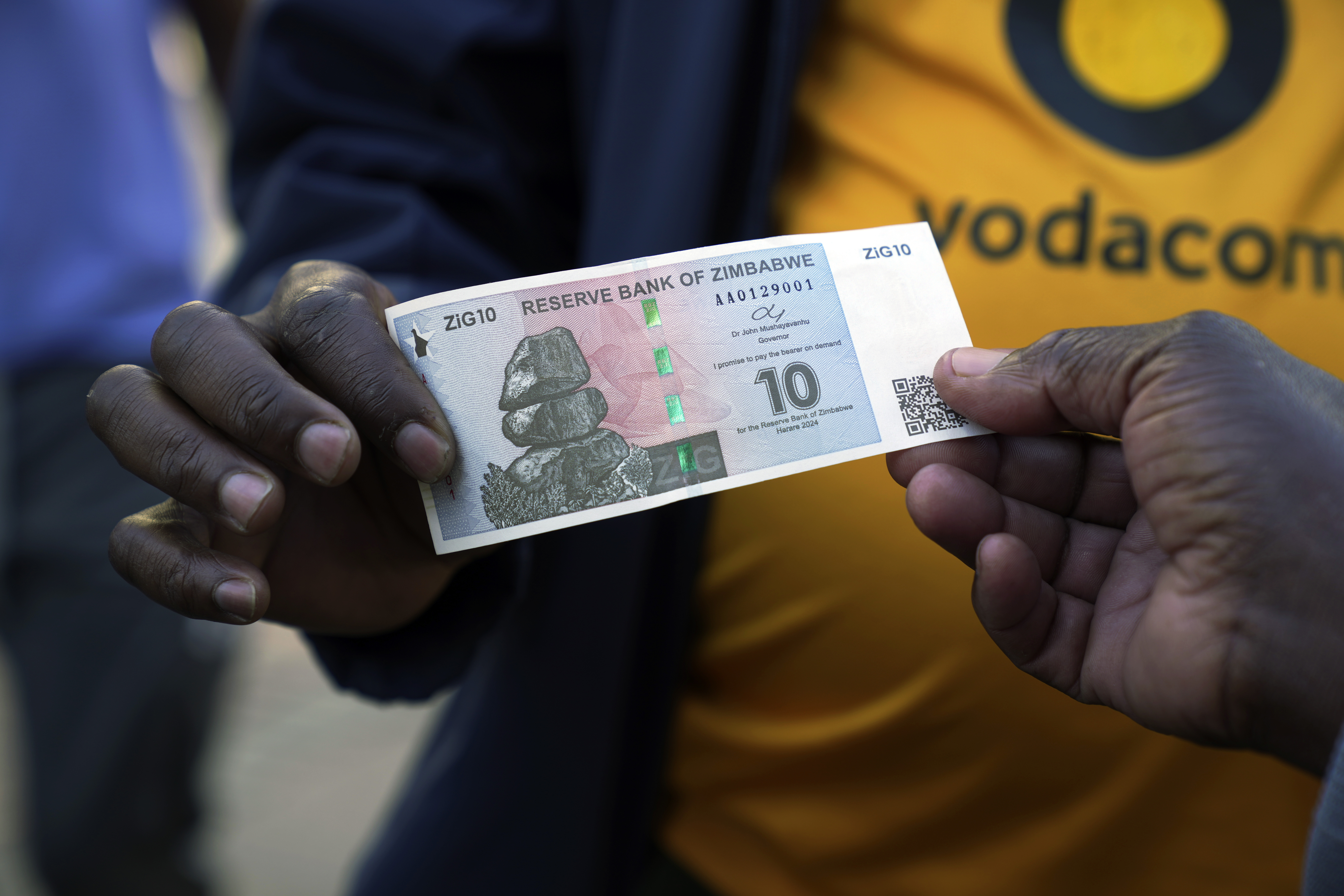Street vendors hold the new currency note, the ZiG, in Harare, Zimbabwe.