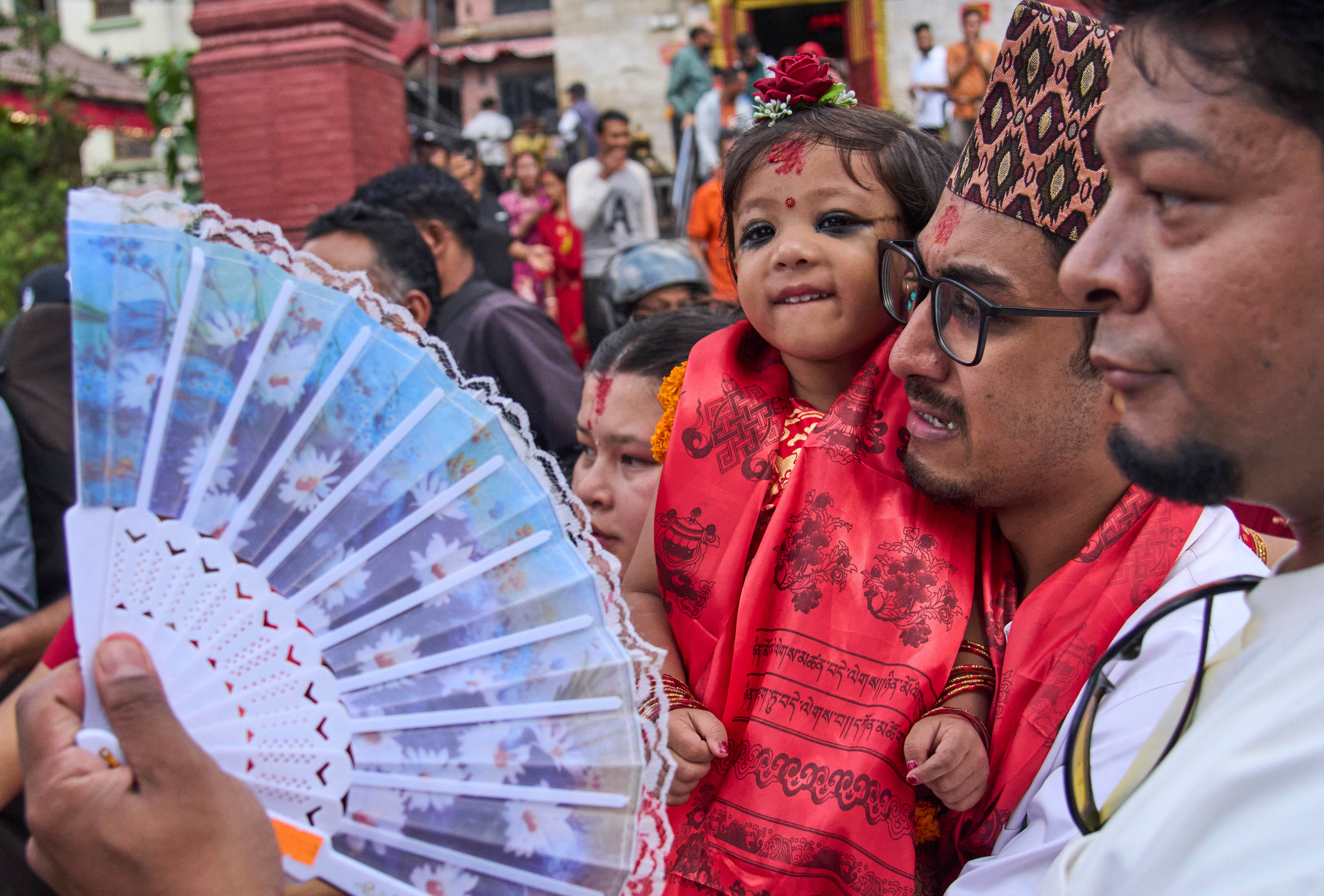 Nepal's newly appointed living goddess, Kumari Aryatara Shakya, is carried by her father as they walk towards Kumari Ghar, the temple palace where she will be residing in Kathmandu, Nepal,