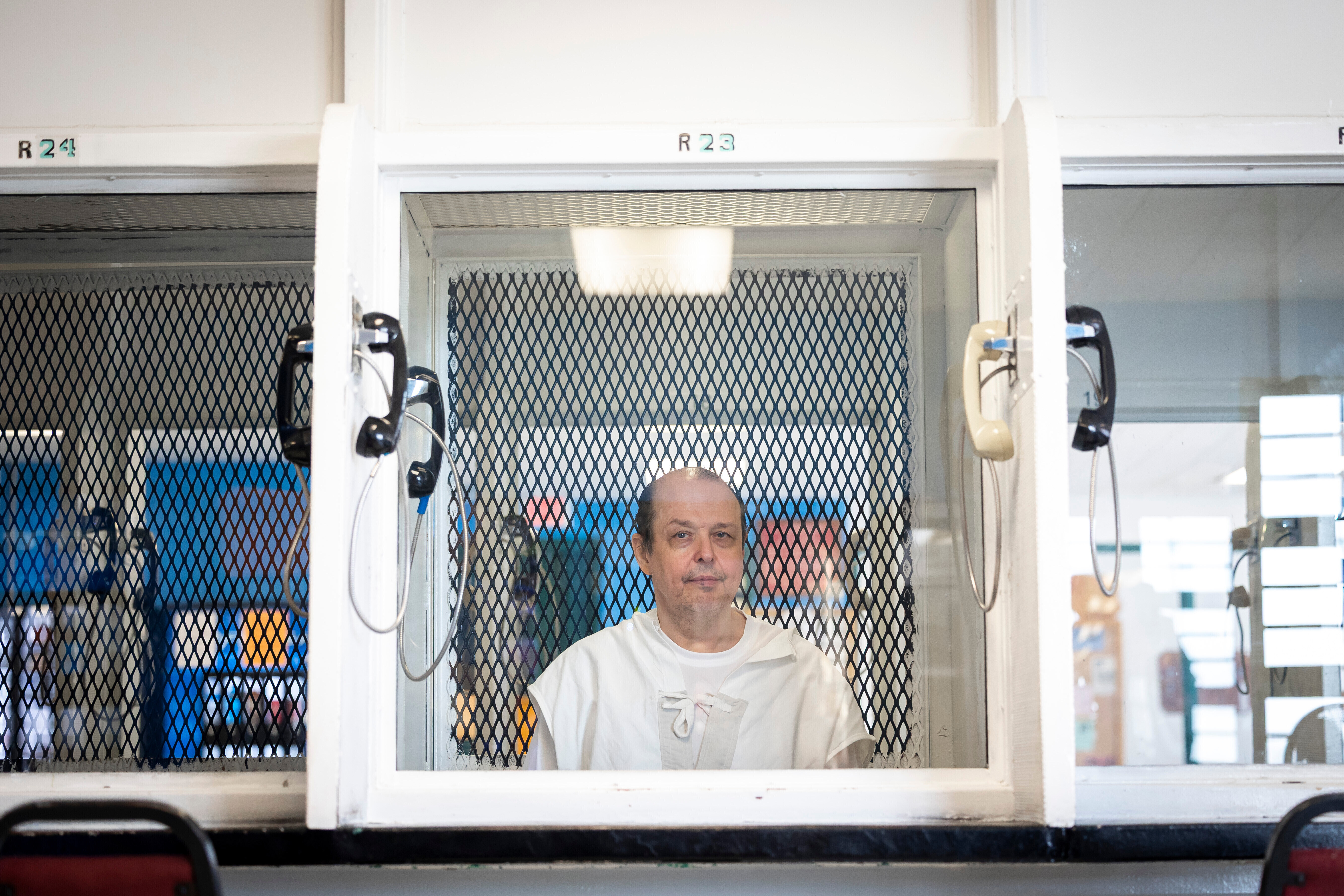 Robert Roberson in a phone booth to talk to visitors in a Texas prison.