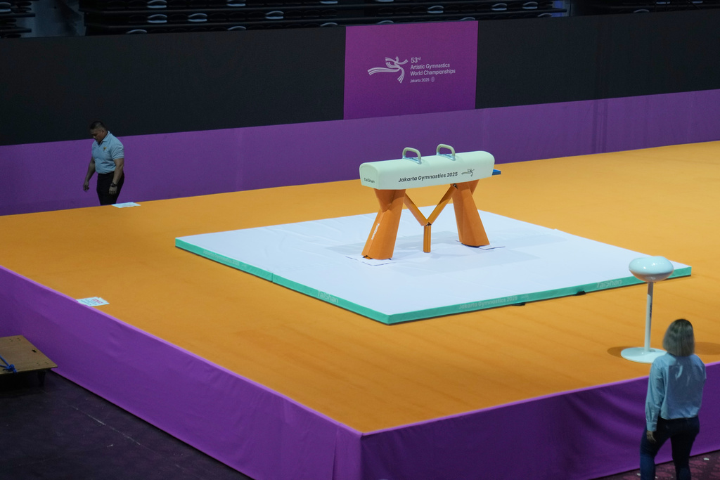 A security guard walks past a pommel horse at the venue prepared for the Artistic Gymnastics World Championships at Indonesia