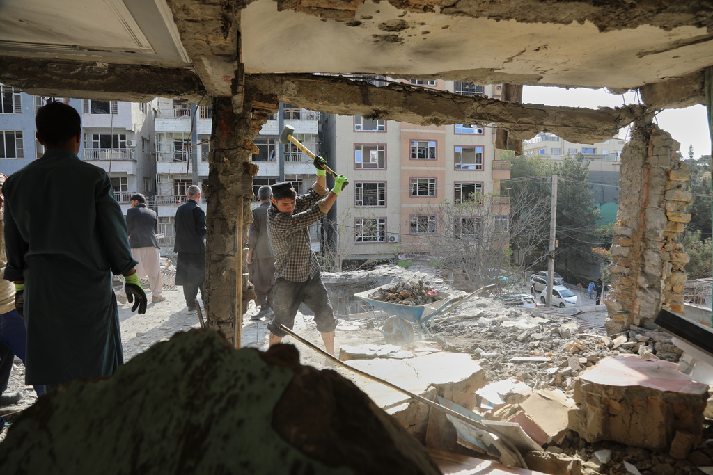 Residents remove debris from a house damaged by attacks.