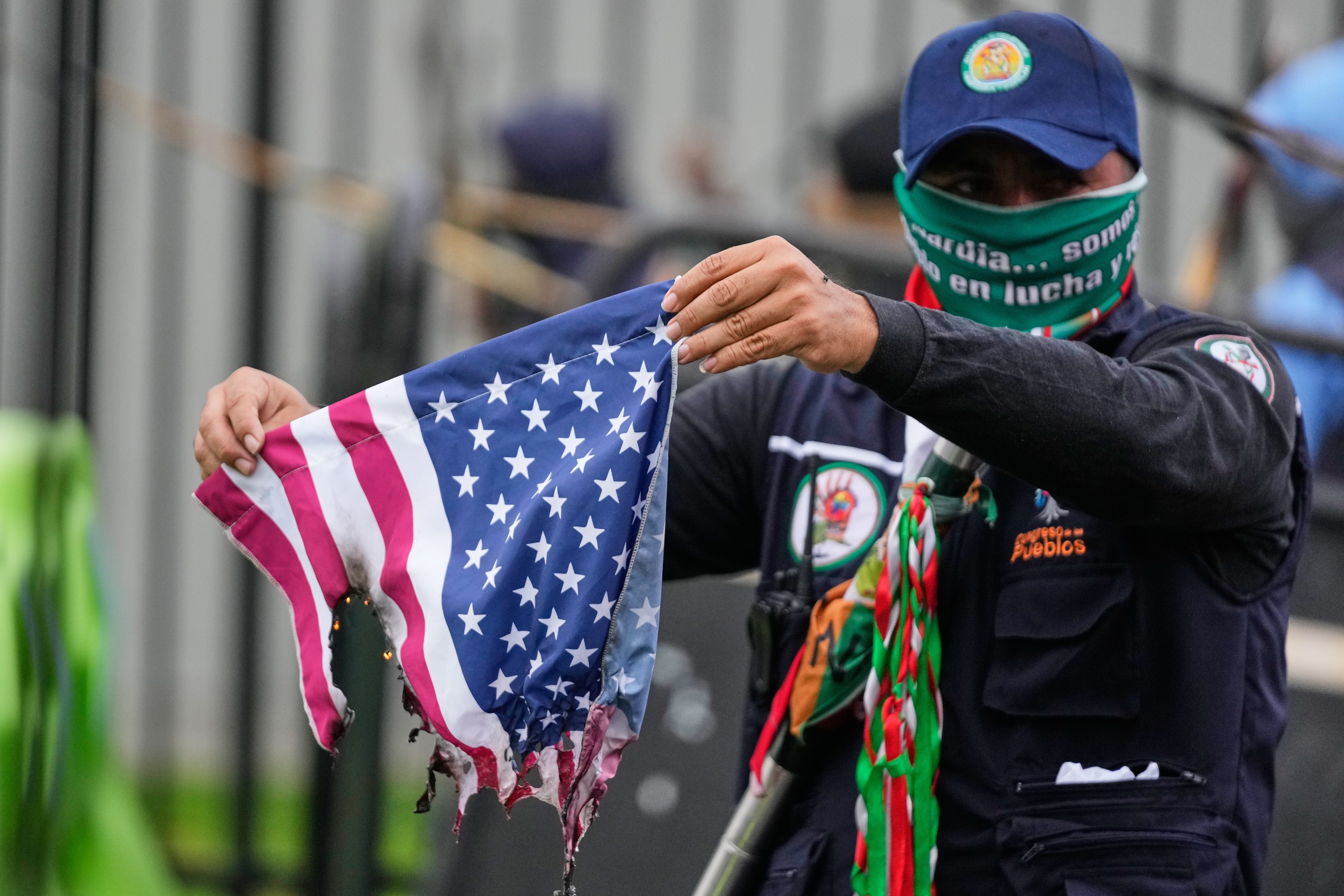A protester in Colombia burns a US flag.