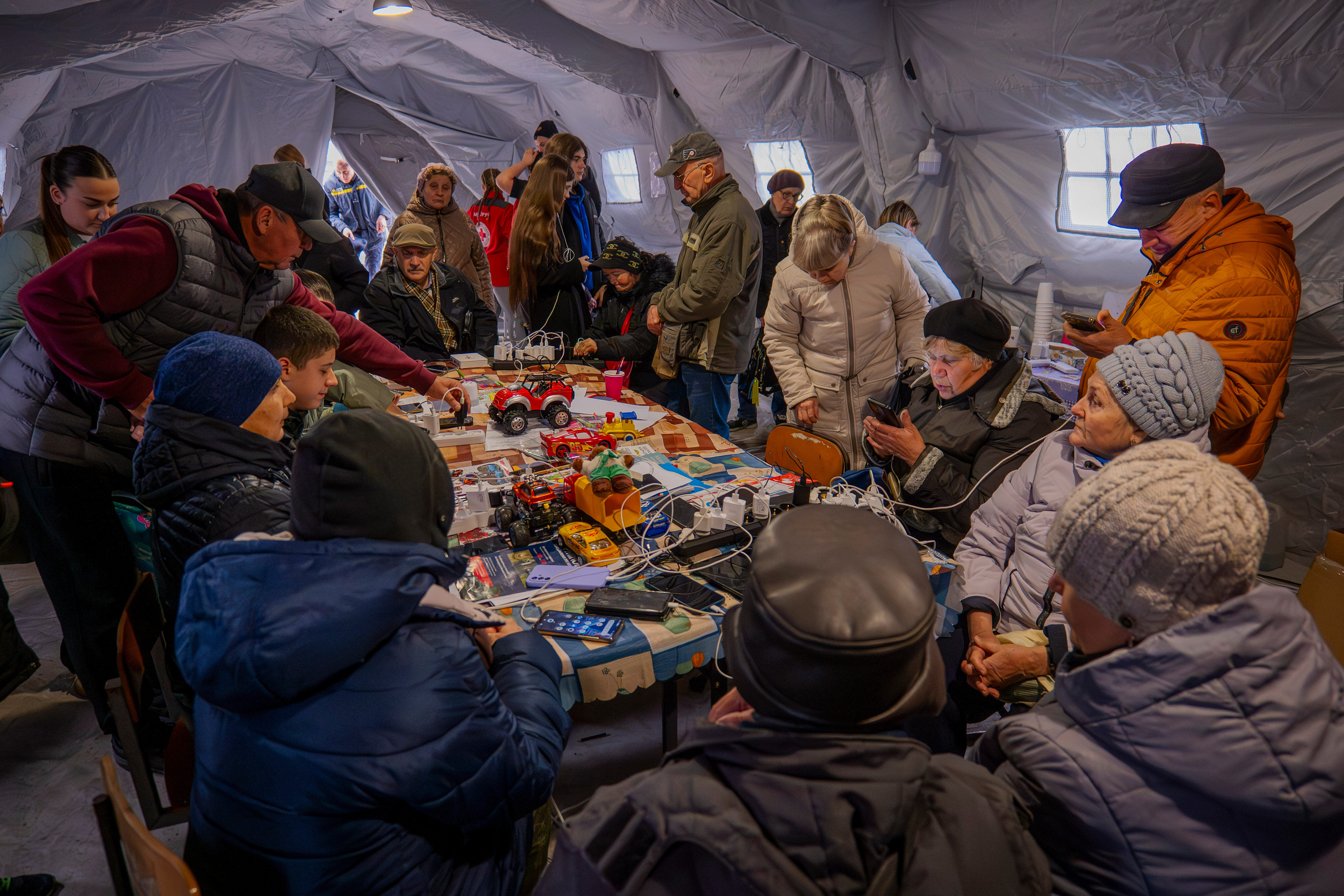 People charge their phones at one of the heated tents called points of invincibility, government-built help stations