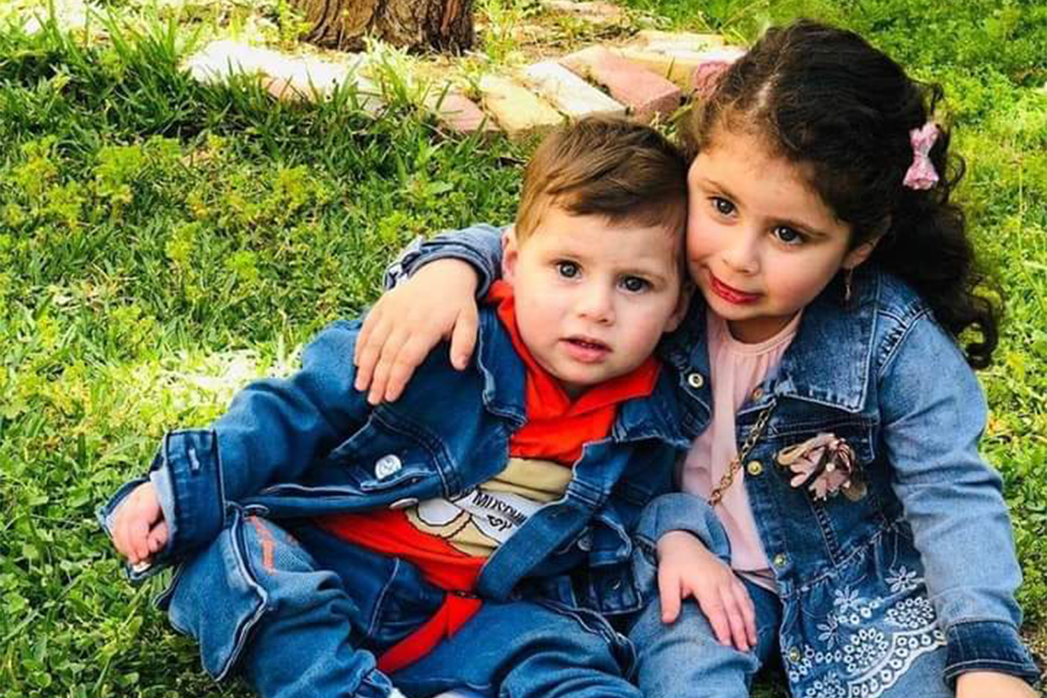 Ali's sister with her arm over his shoulder, as they sit in their garden in southern Lebanon.