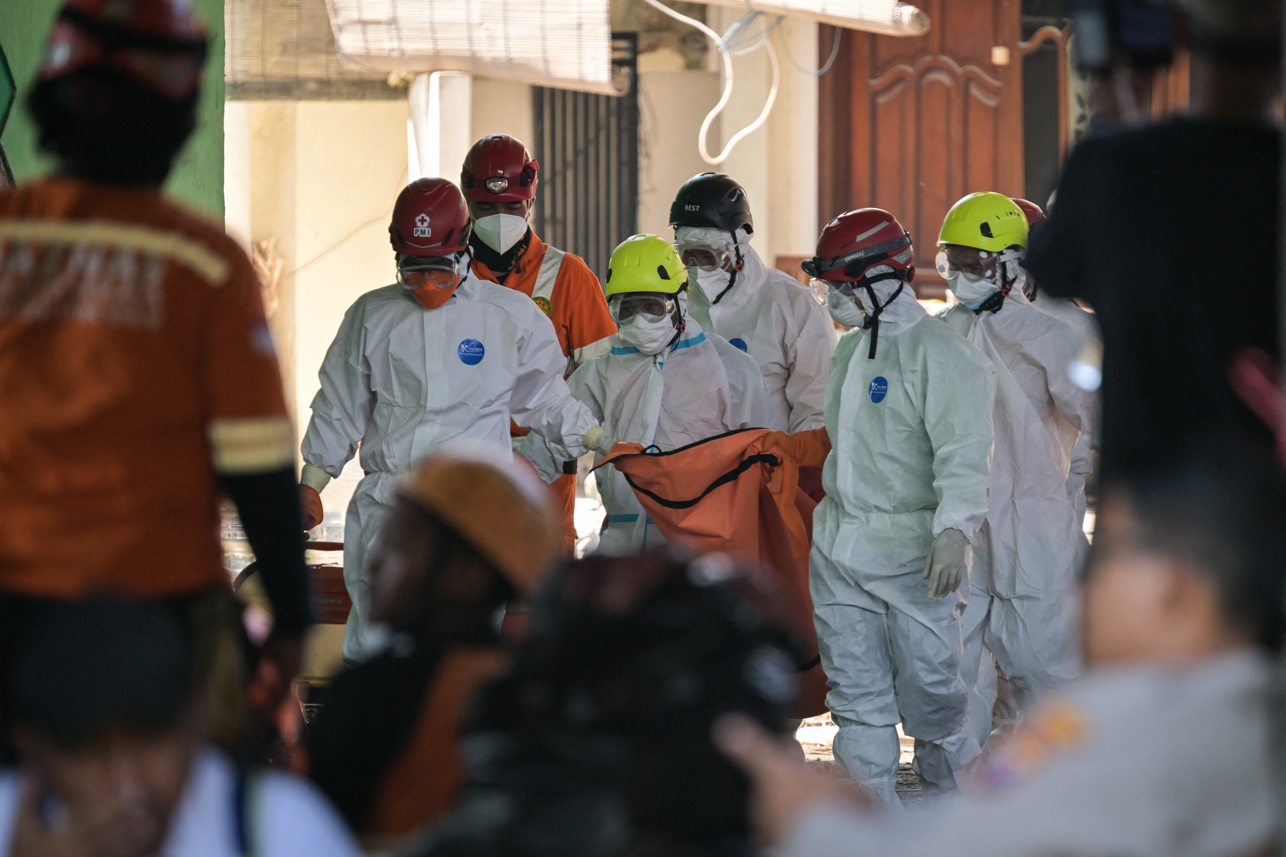 Rescue team members carry a body bag from the site of the collapsed Al Khoziny Islamic boarding school in Sidoarjo, East Java, on October 6, 2025, as recovery efforts continue.