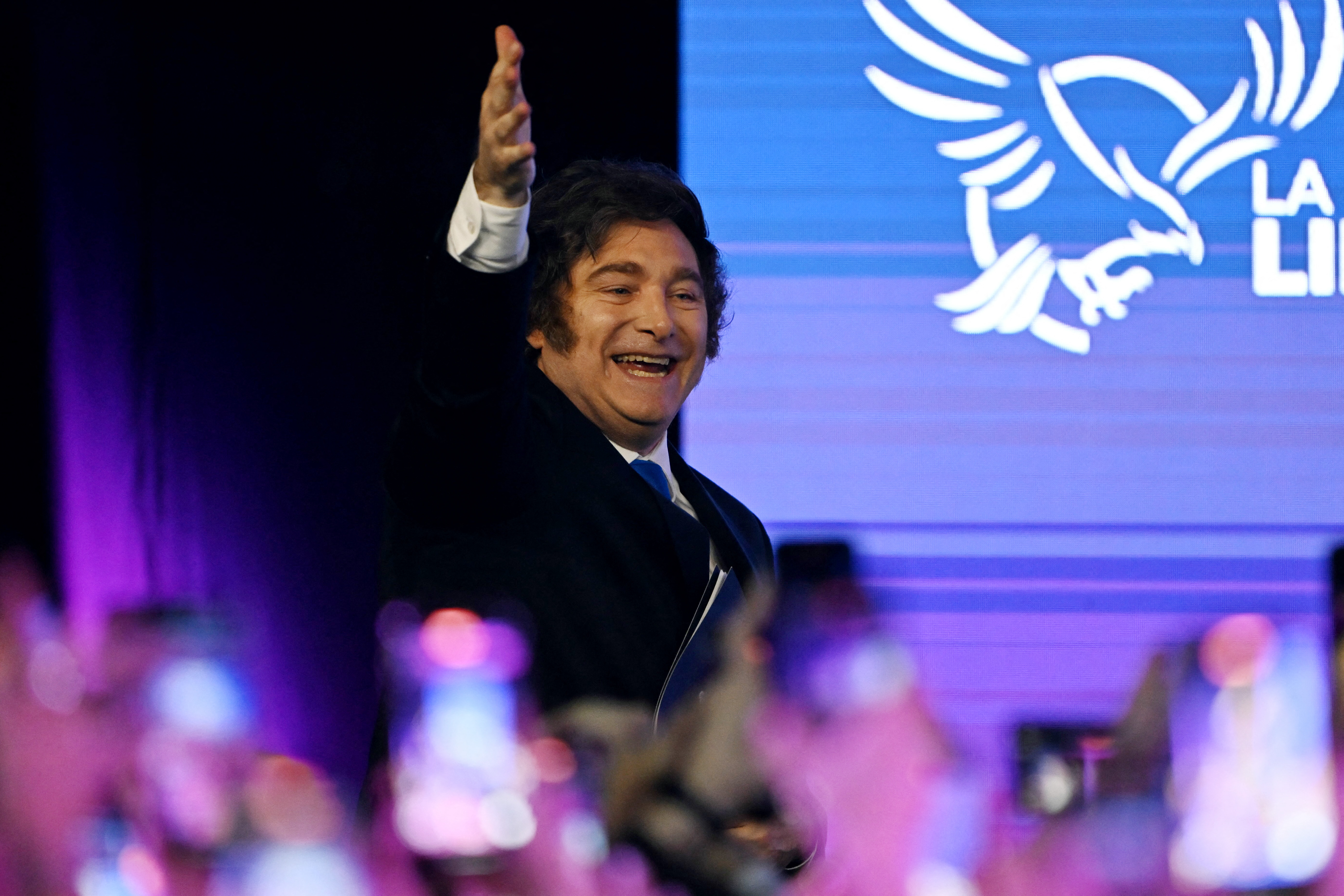 Argentina's President Javier Milei waves to supporters as he arrives at the ruling party's La Libertad Avanza headquarters following the results of the national midterm legislative election in Buenos Aires on October 26, 2025.