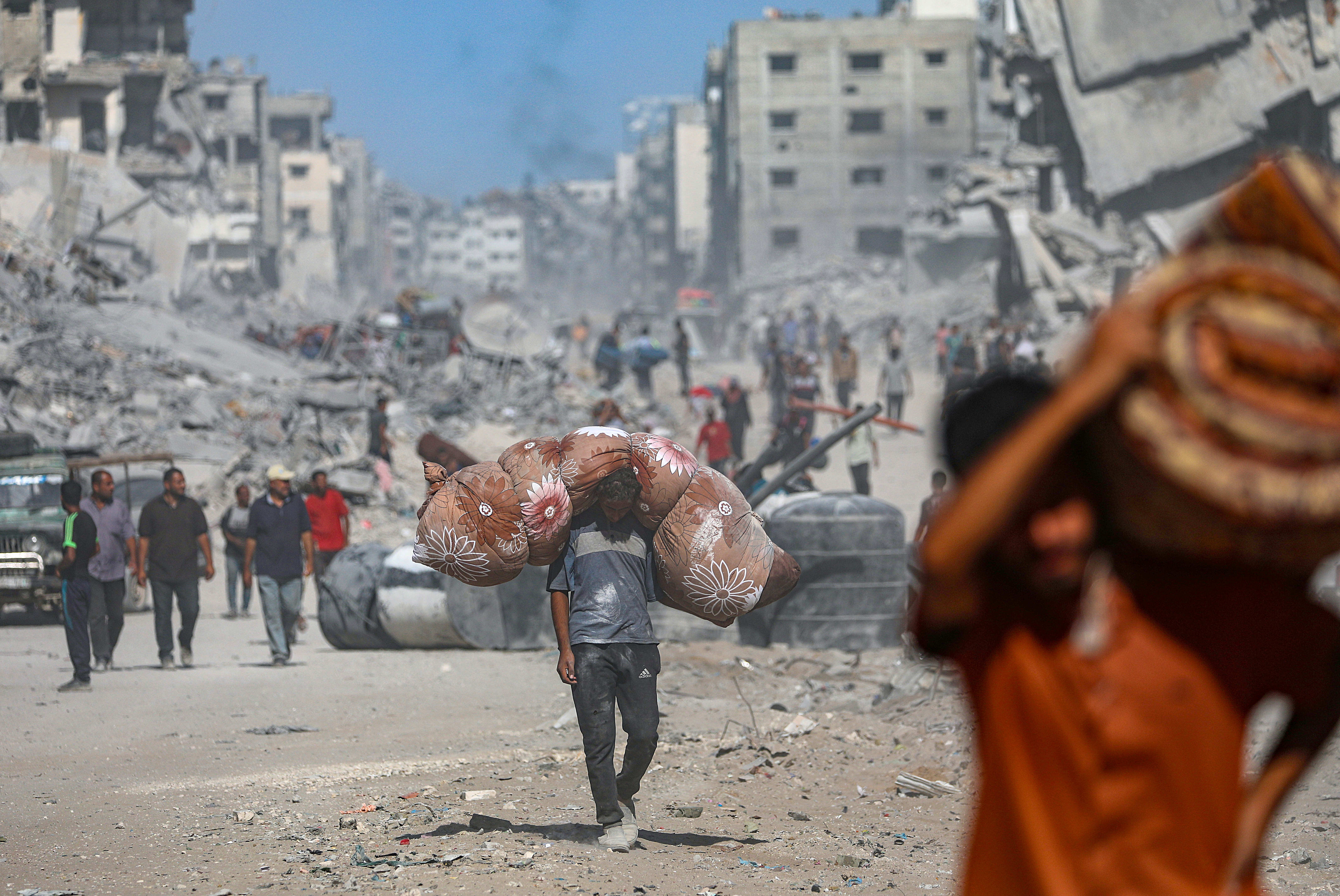 epa12447093 Internally displaced Palestinians walk along a street among the rubble of destroyed buildings amid a ceasefire between Israel and Hamas, in Gaza City, 11 October 2025. US President Donald Trump announced that Israel and Hamas have agreed to the first phase of a Gaza peace plan. The deal involves the release of Israeli hostages and Palestinian prisoners, the withdrawal of Israeli forces, and the delivery of humanitarian aid to Gaza. EPA/MOHAMMED SABER