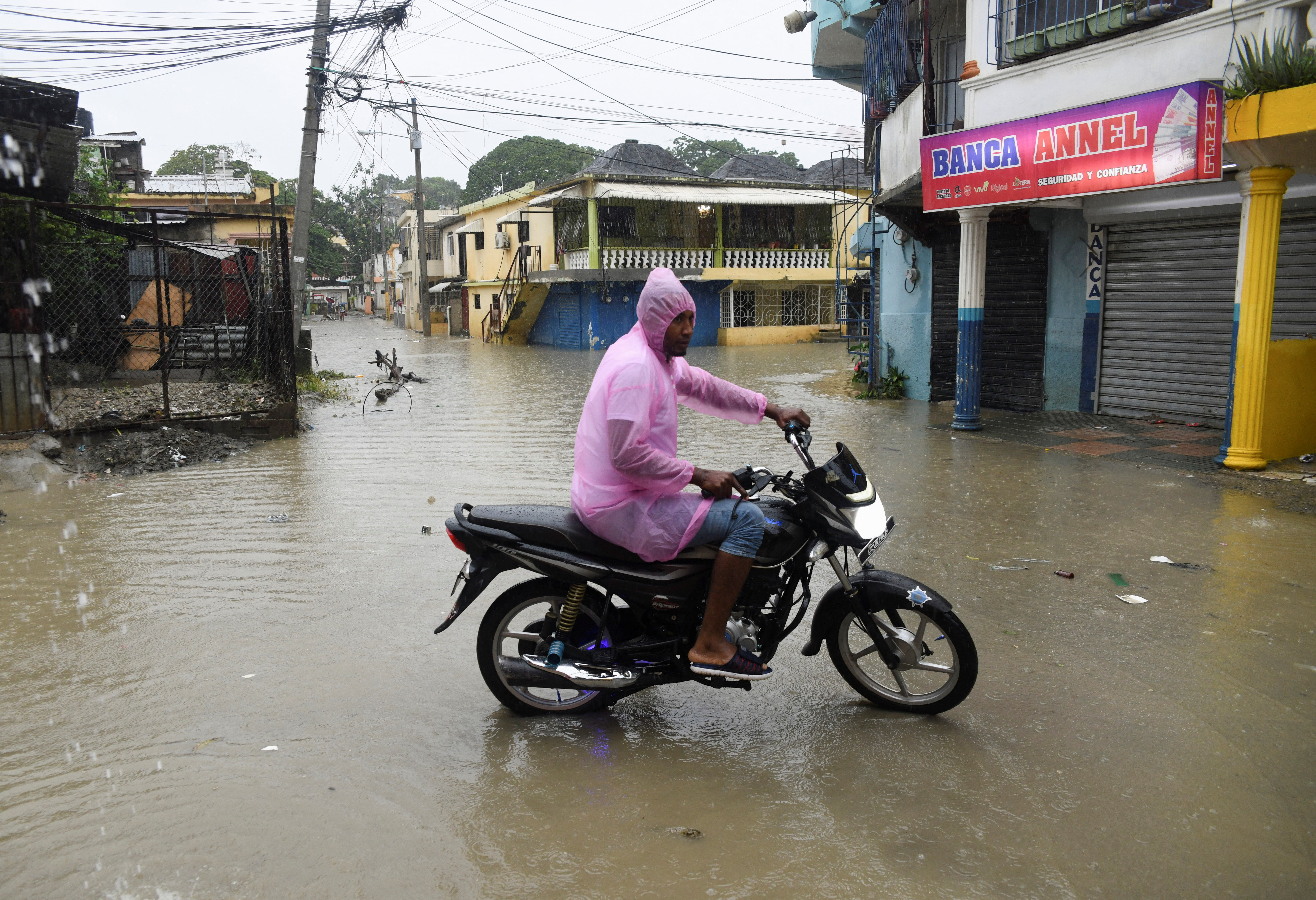 A man rides a motorcycle on a flooded street amid rain caused by Tropical Storm Melissa, in Santo Domingo, Dominican Republic, October 24, 2025. REUTERS/Eddy Vittini