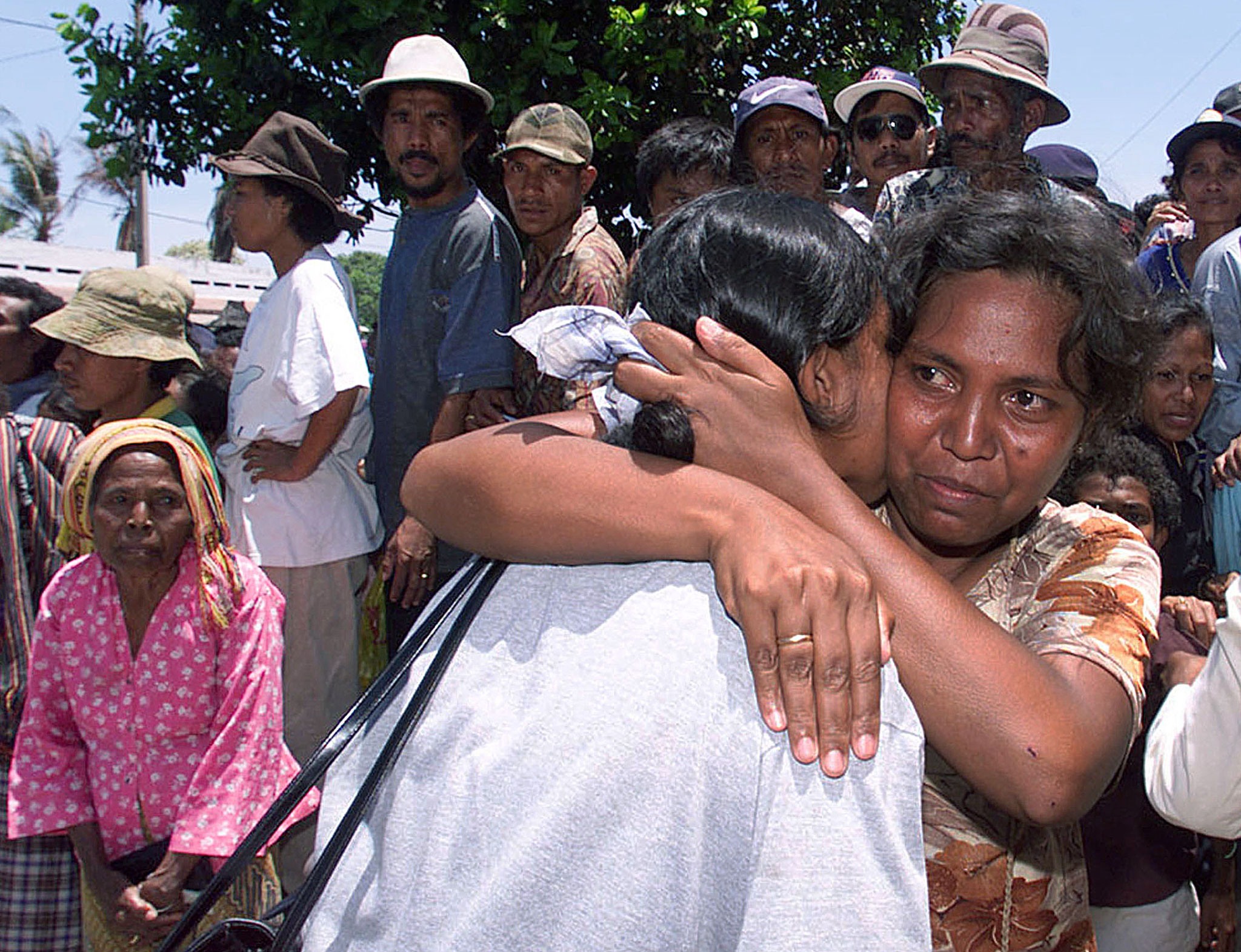 Two East Timorese women reunite in Dili October 9 as others wait for the chance to meet with missing friends and relatives off a flight from West Timor. Up to 100 more refugees arrived from West Timor by humanitarian flights that began October 8, continuing to repatriate East Timorese refugees who were forcibly deported at gunpoint by pro-Jakarta militia to West Timor during violence against a vote for East Timor's independence from Indonesia. JIR/TAN