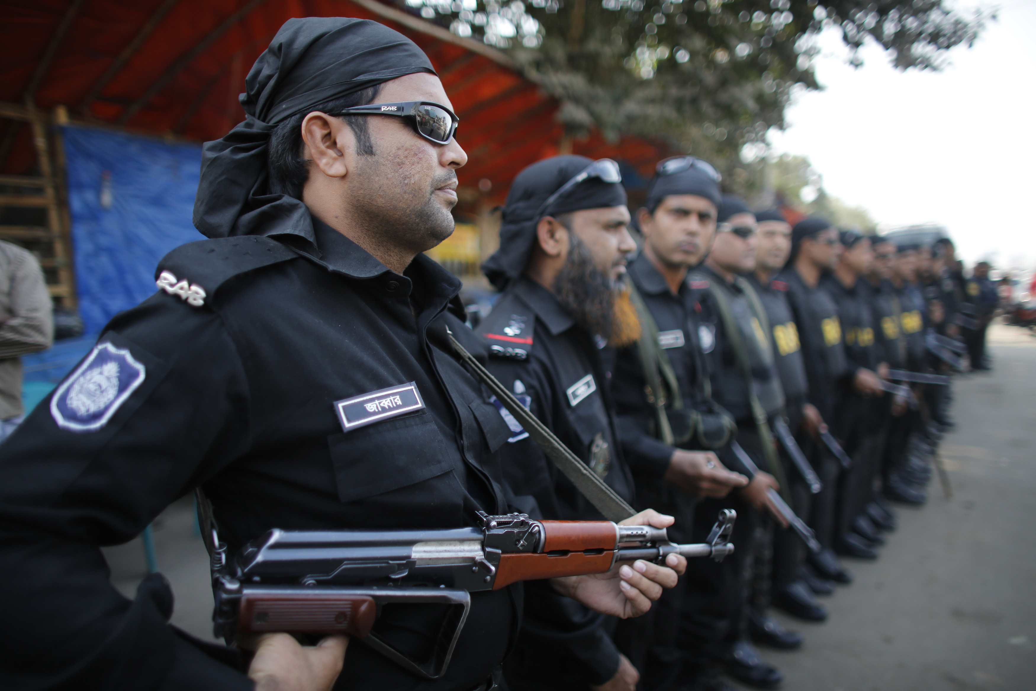 Members of Rapid Action Battalion (RAB) stand guard during a nationwide protest in Dhaka