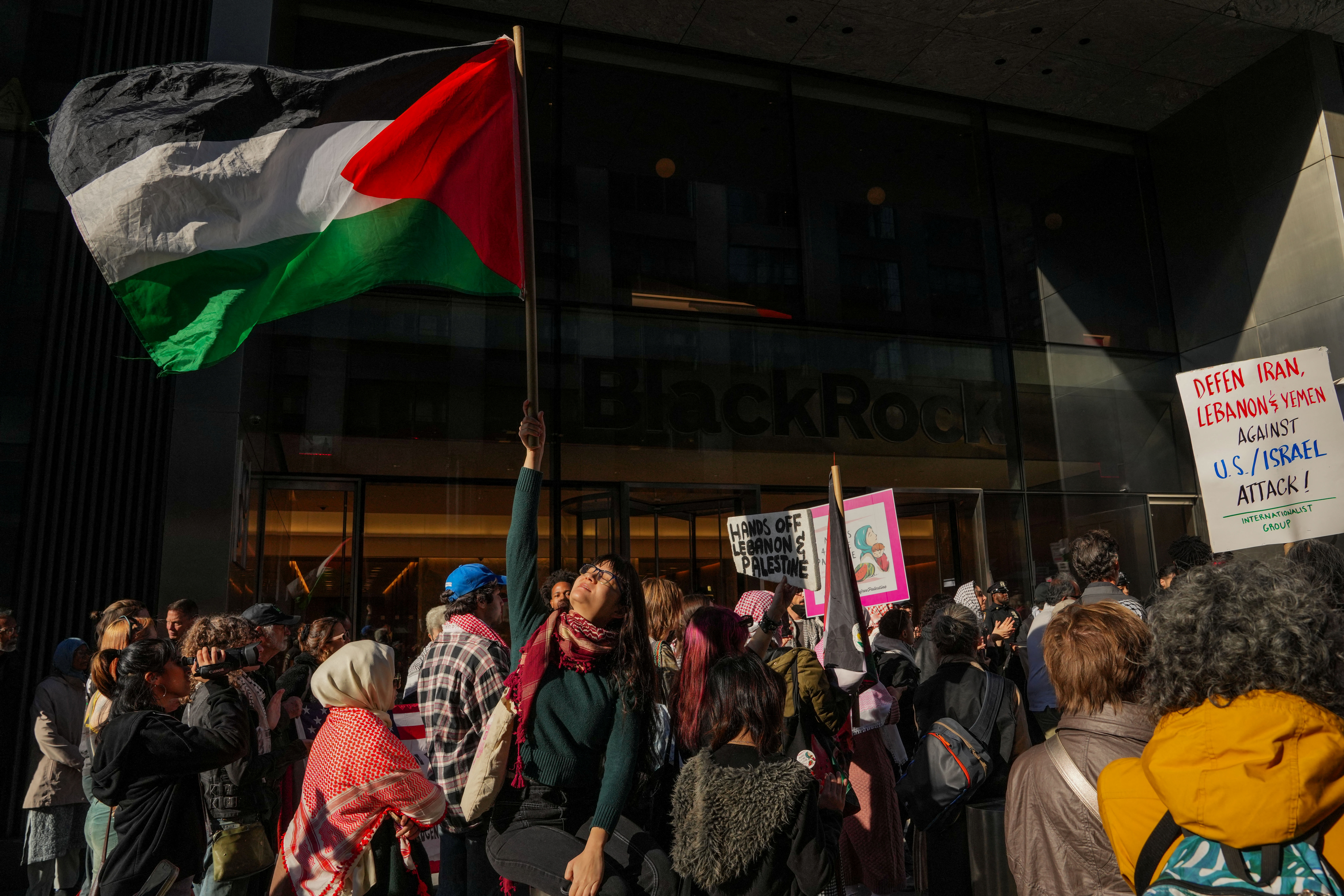 A person holds a Palestinian flag during an “All Out for Palestine” protest against Israeli arms funding [Adam Gray/Reuters]