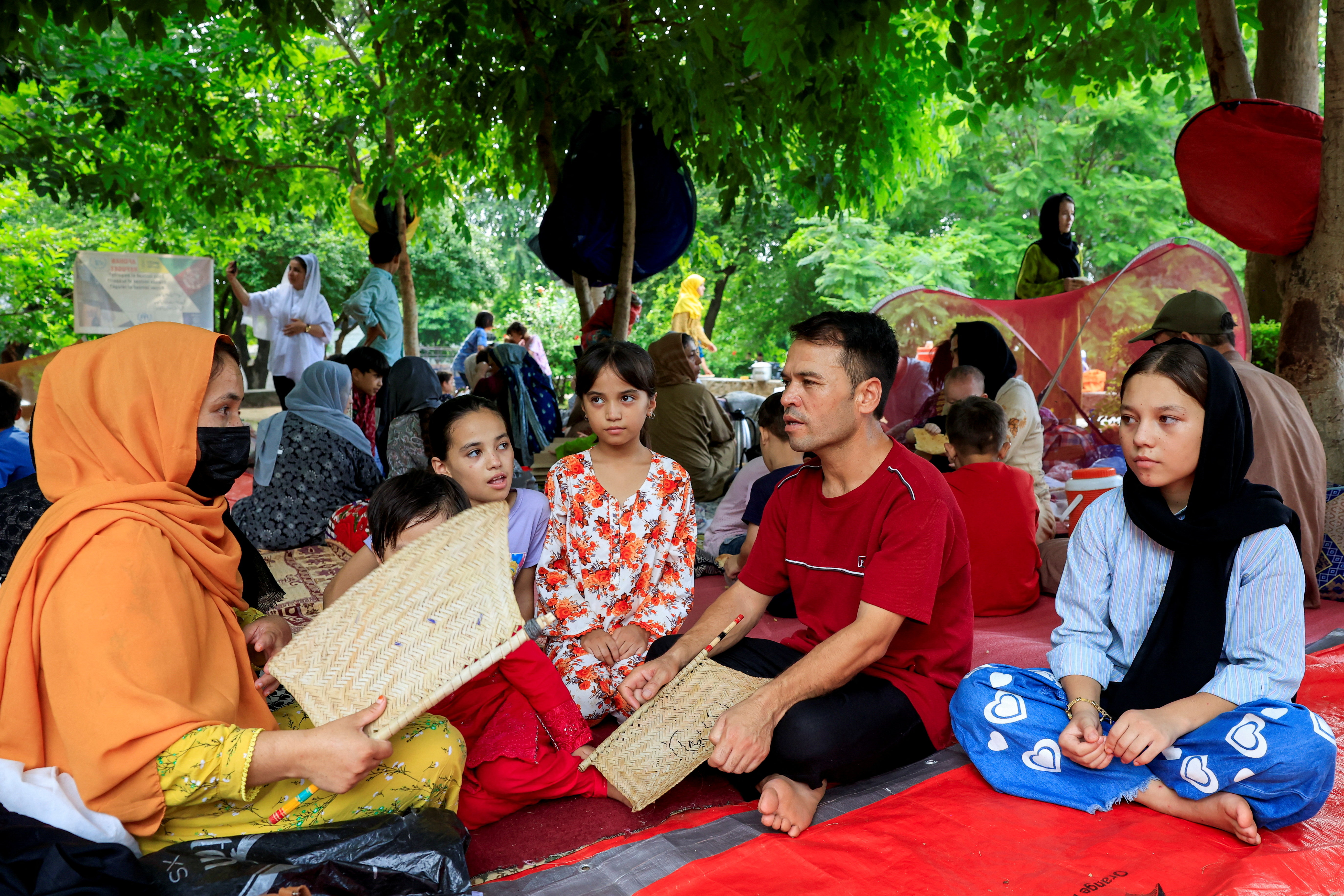 A family take shelter at a public park.