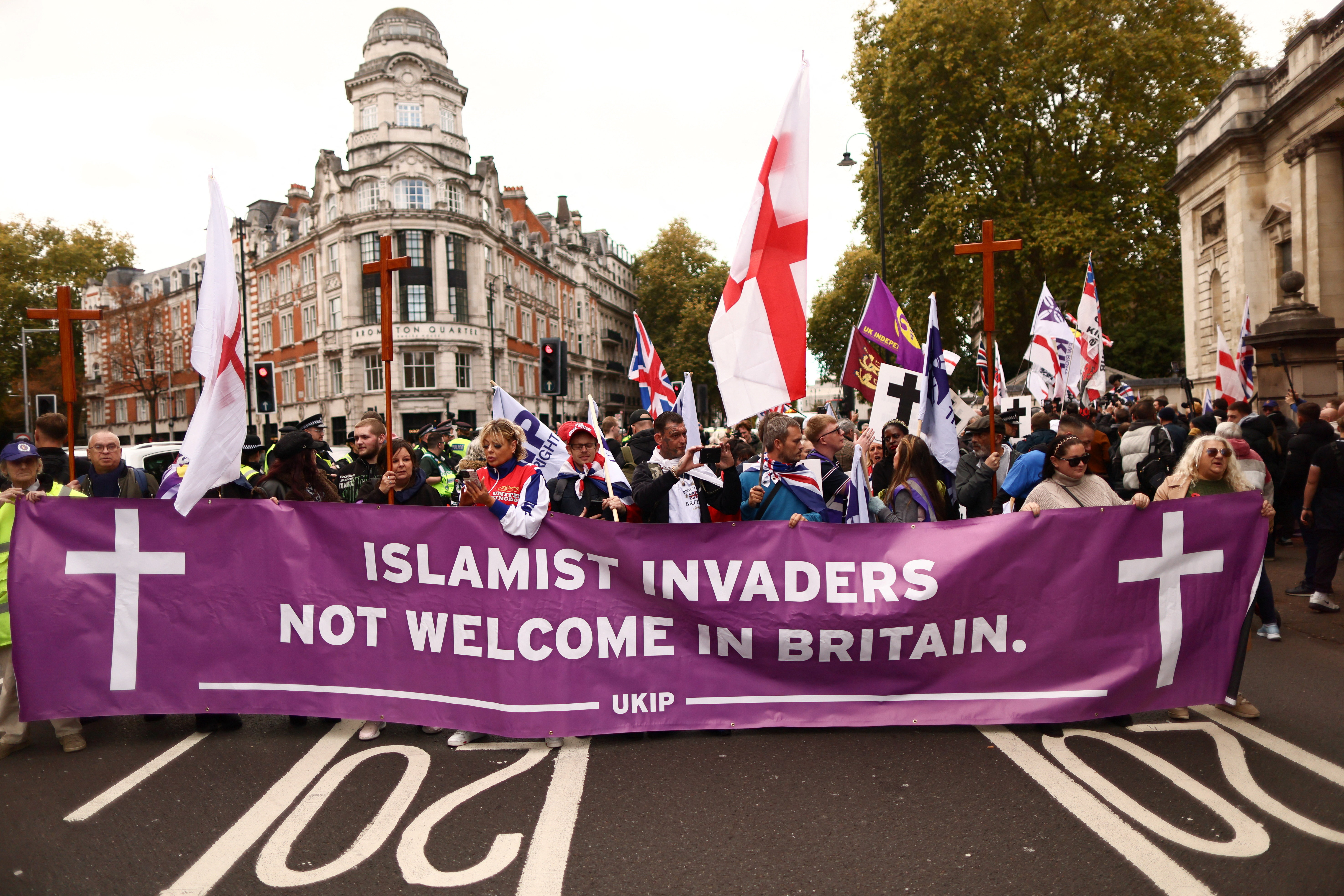 People hold a banner as they gather to attend a United Kingdom Independence Party (UKIP) anti-immigration march in central London, Britain, on October 25, 2025 [REUTERS/Jack Taylor] 